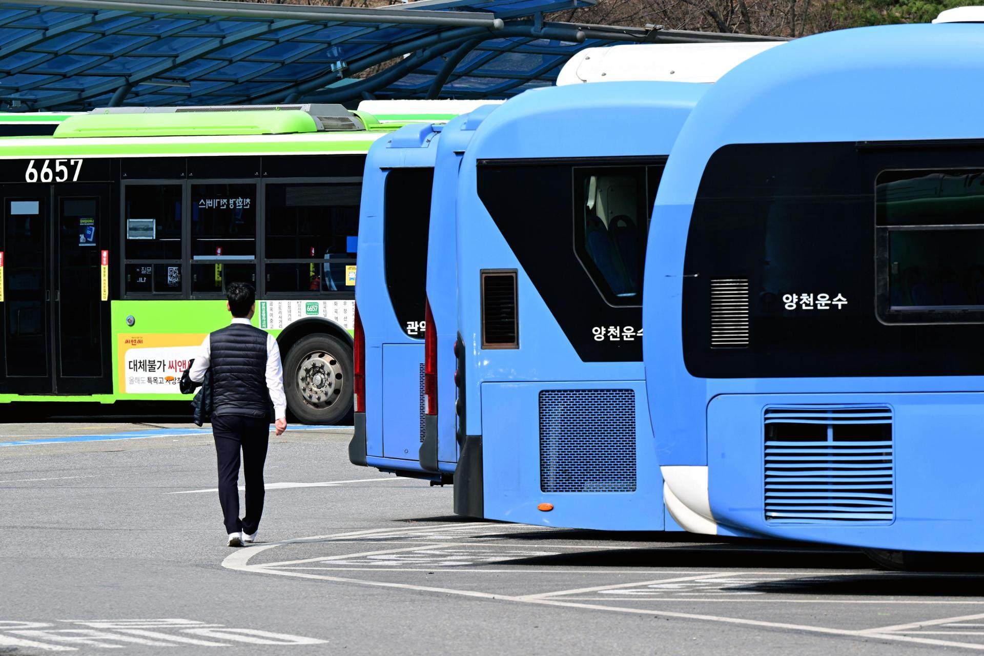 A bus driver walks between parked buses at the Yangcheon Public Garage in Seoul. Photo: The Korea Times