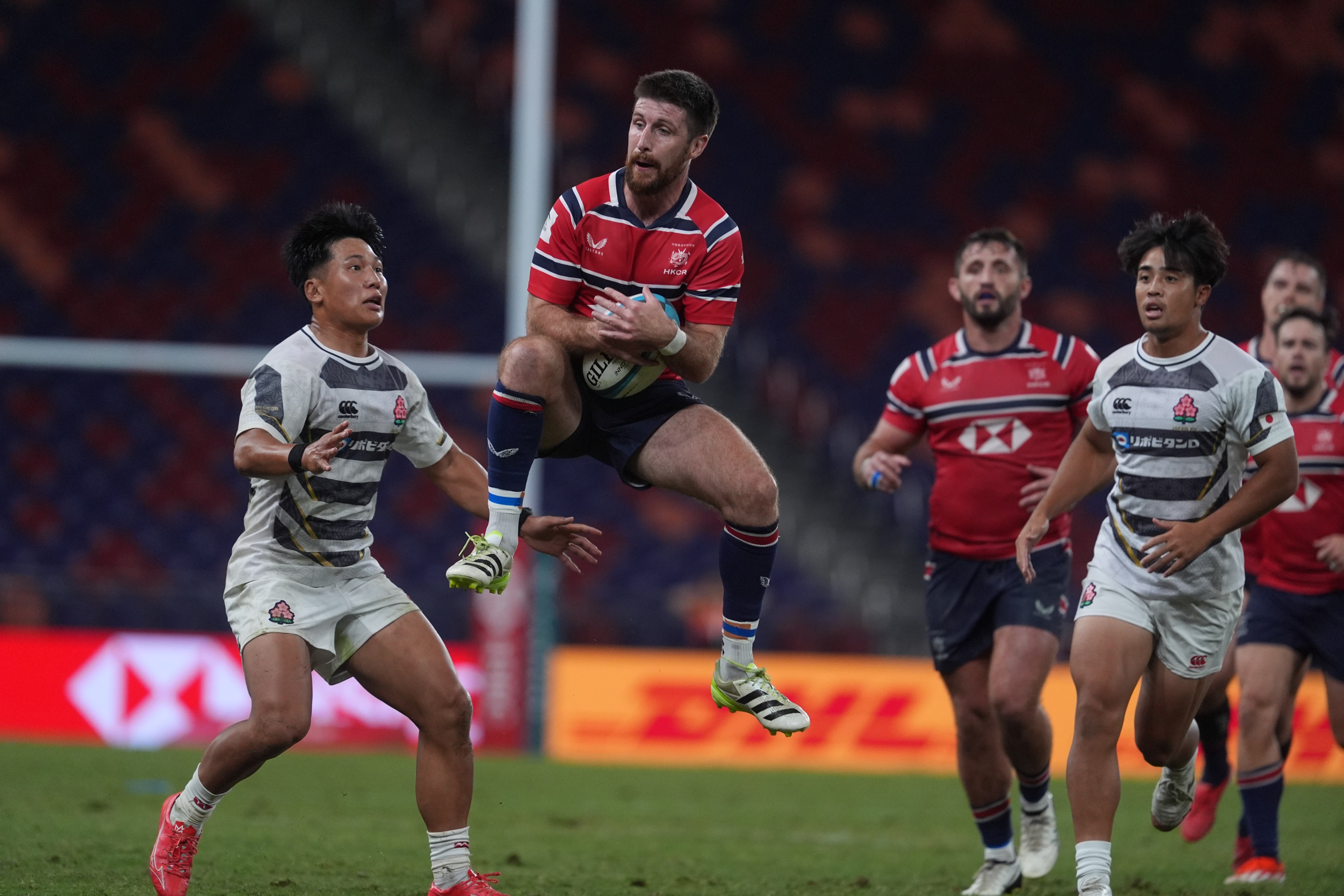 Hong Kong’s Gregor McNeish catches a high ball under pressure from Japan A’s Yuto Mori (left) during a game at Kai Tak Stadium last October. Photo: Elson Li