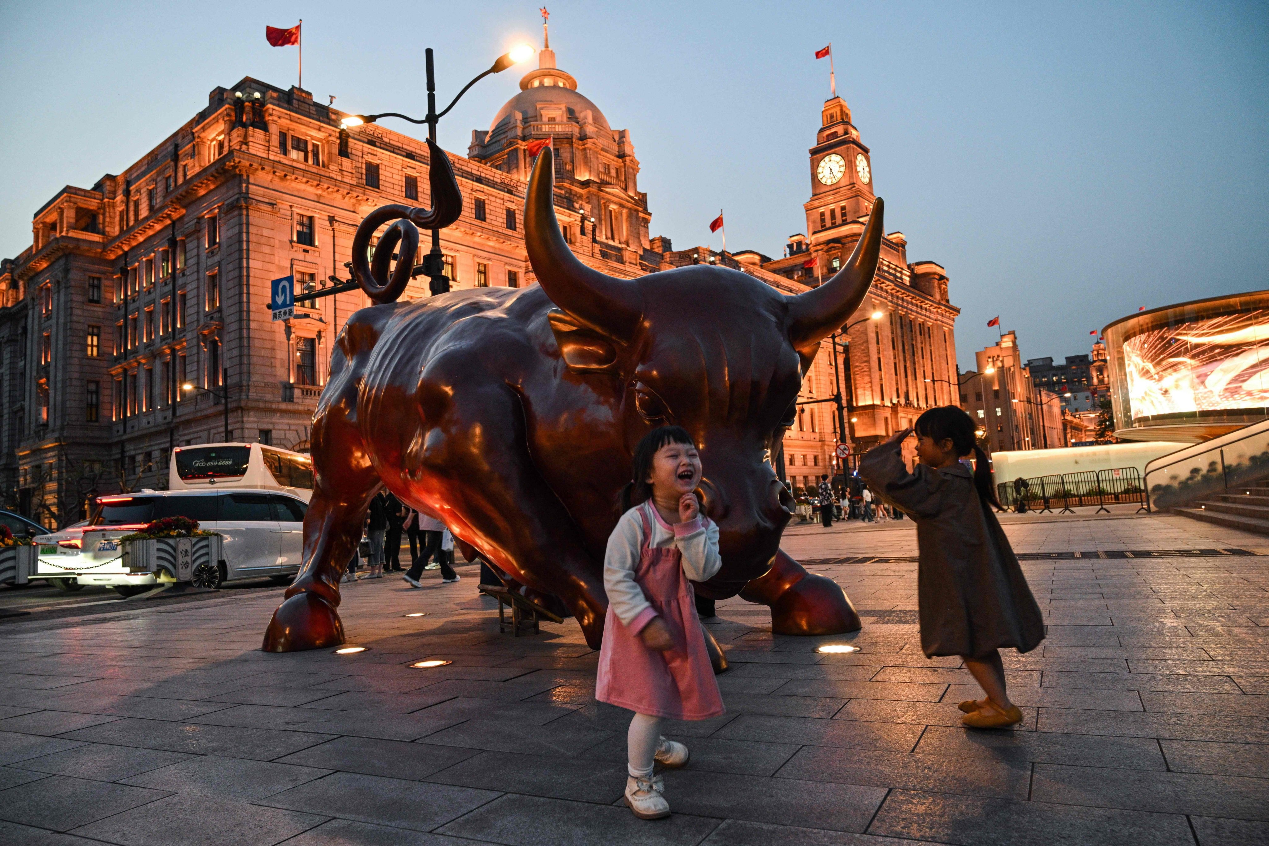 Children play next to The Bund Bull sculpture in Shanghai on April 9, 2025. Photo: AFP