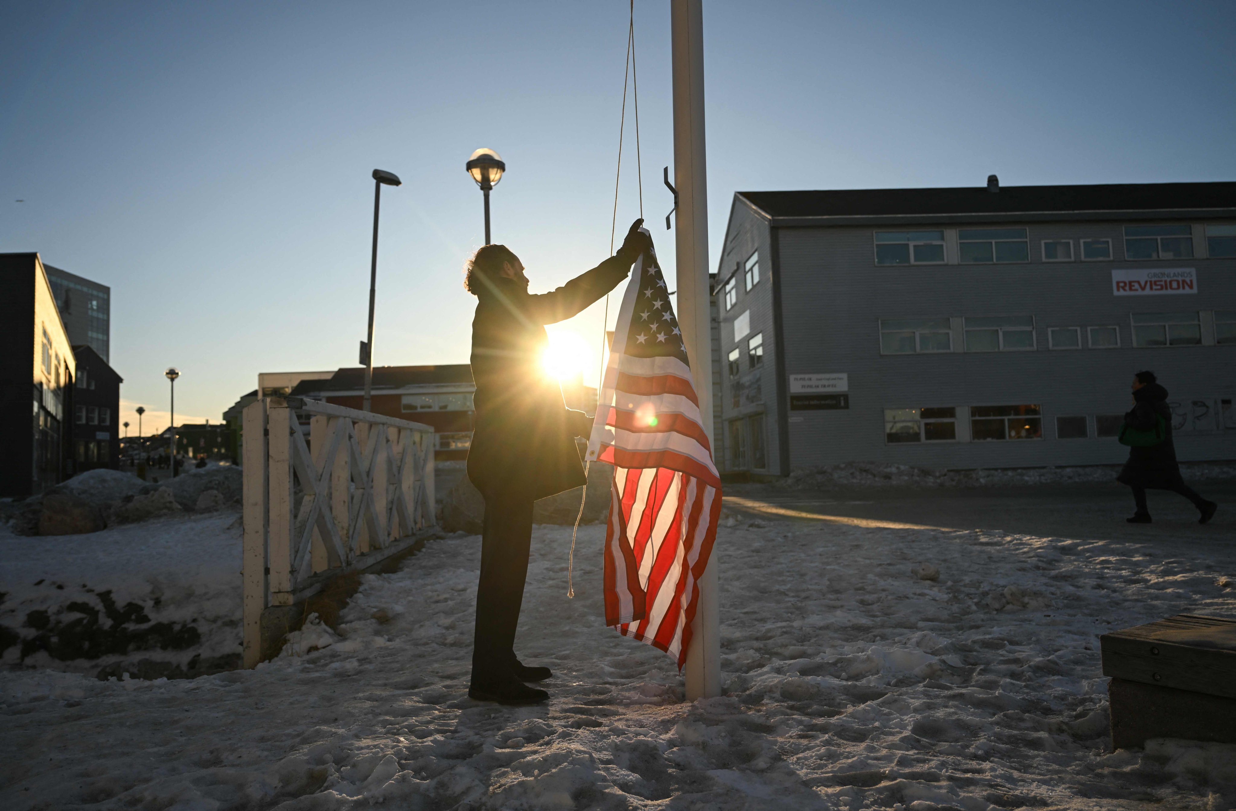 German Comedian Maxi Schafroth tries to raise an American flag in Nuuk, Greenland, on Thursday. Photo: AFP