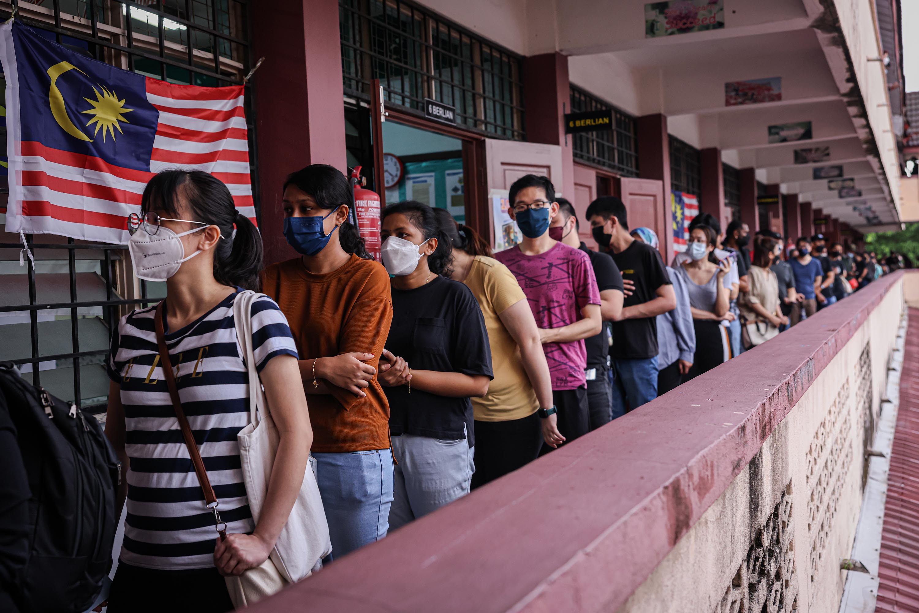 Voters wait in line at a polling station during Malaysia’s 15th general election on November 19, 2022, in Kuala Lumpur. Photo: TNS