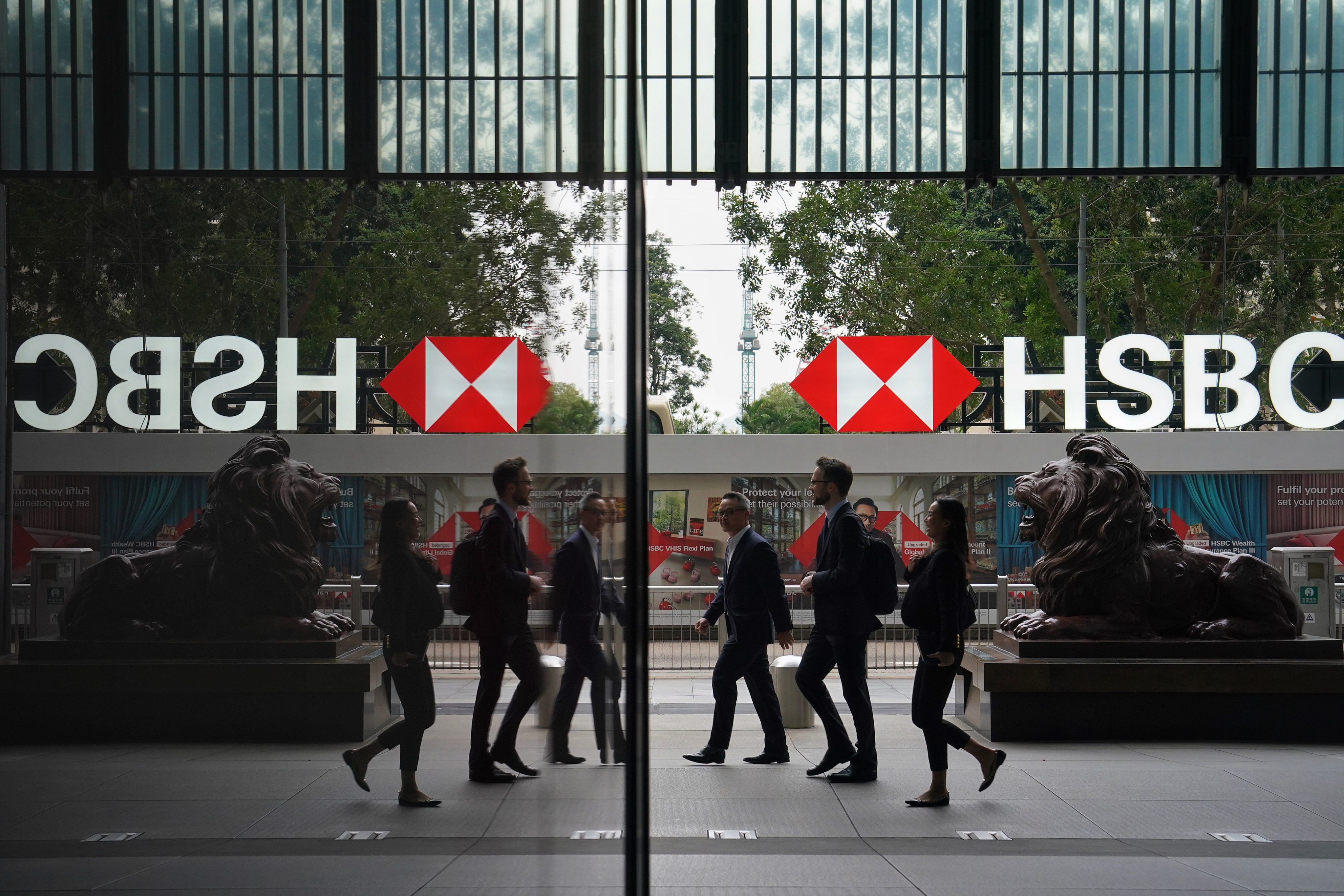 Pedestrians walk past the lion statues outside HSBC’s Hong Kong headquarters in Central.  Photo: Elson Li