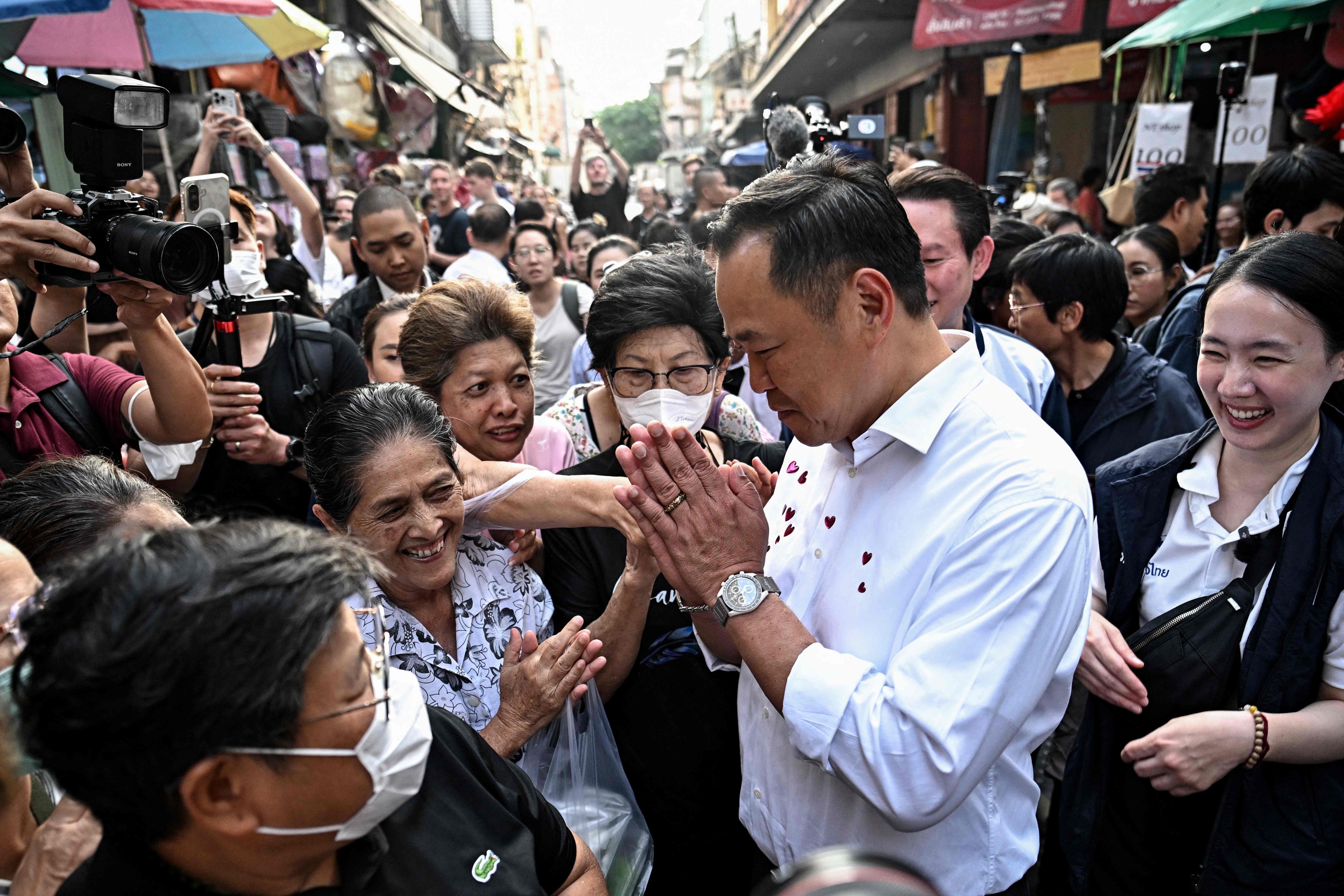 Thailand’s prime minister and Bhumjaithai Party leader Anutin Charnvirakul (second from right) greets people at a market during an election campaign at Chinatown in Bangkok on January 20. Photo: AFP