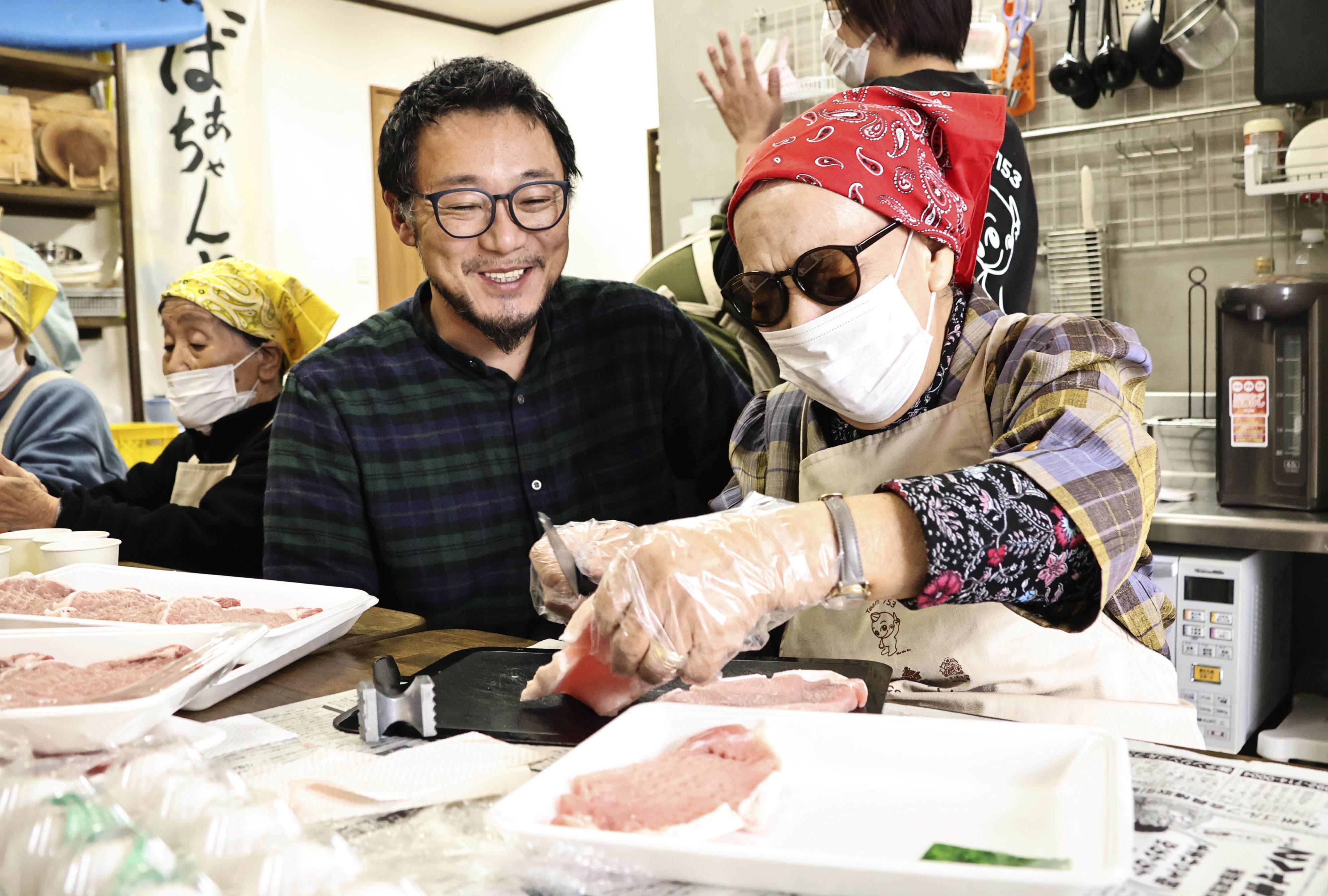 Ukiha no Takara president and CEO Mitsuru Okuma (left) watches Masako Taniguchi make pork cutlets at Grandma’s Tearoom in Fukuoka on November 13, 2025. Photo: Kyodo