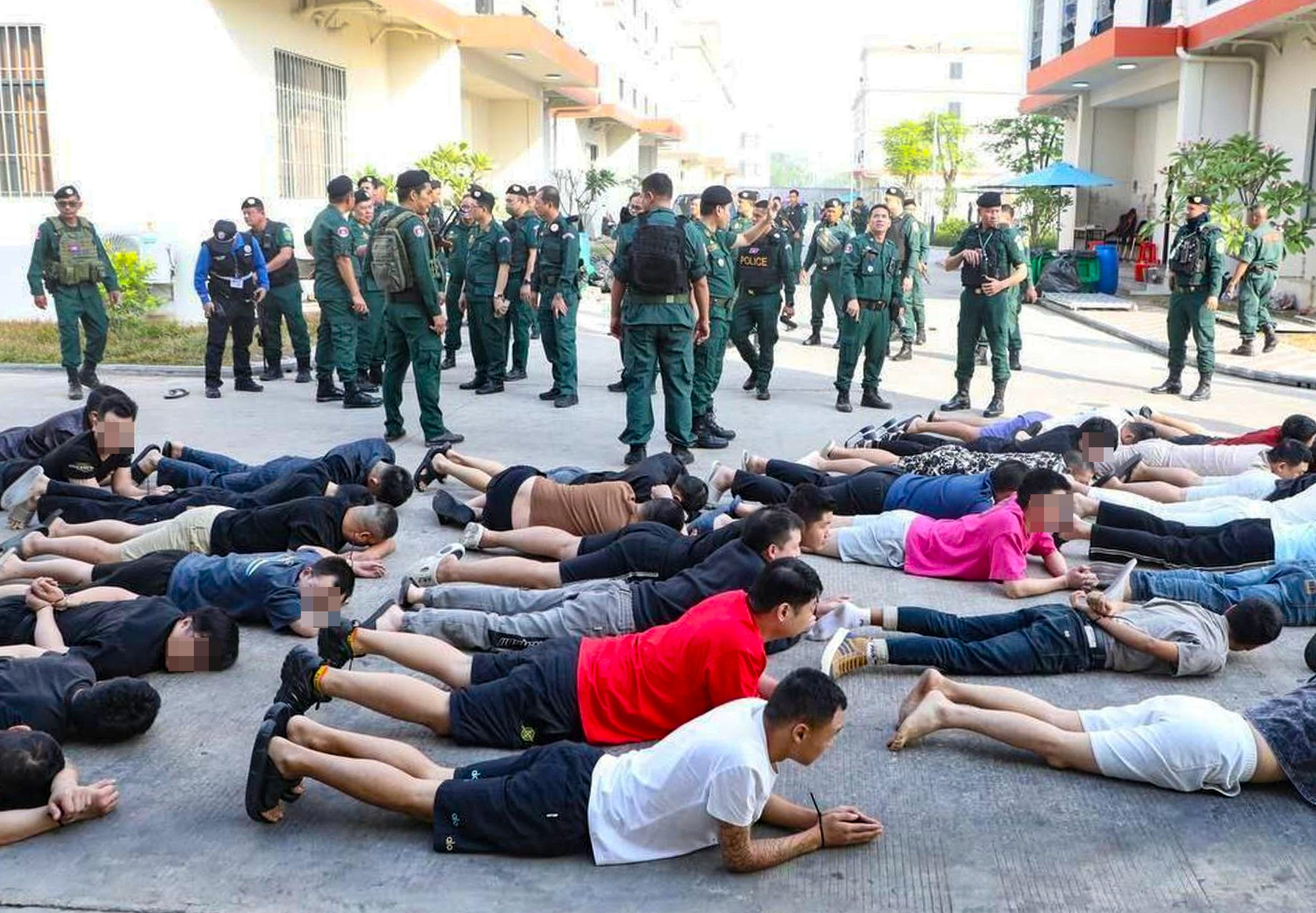 Apprehended suspects are lined up on the ground following a massive raid on a scam compound in Bavet city, southeastern Cambodia. Photo: Handout