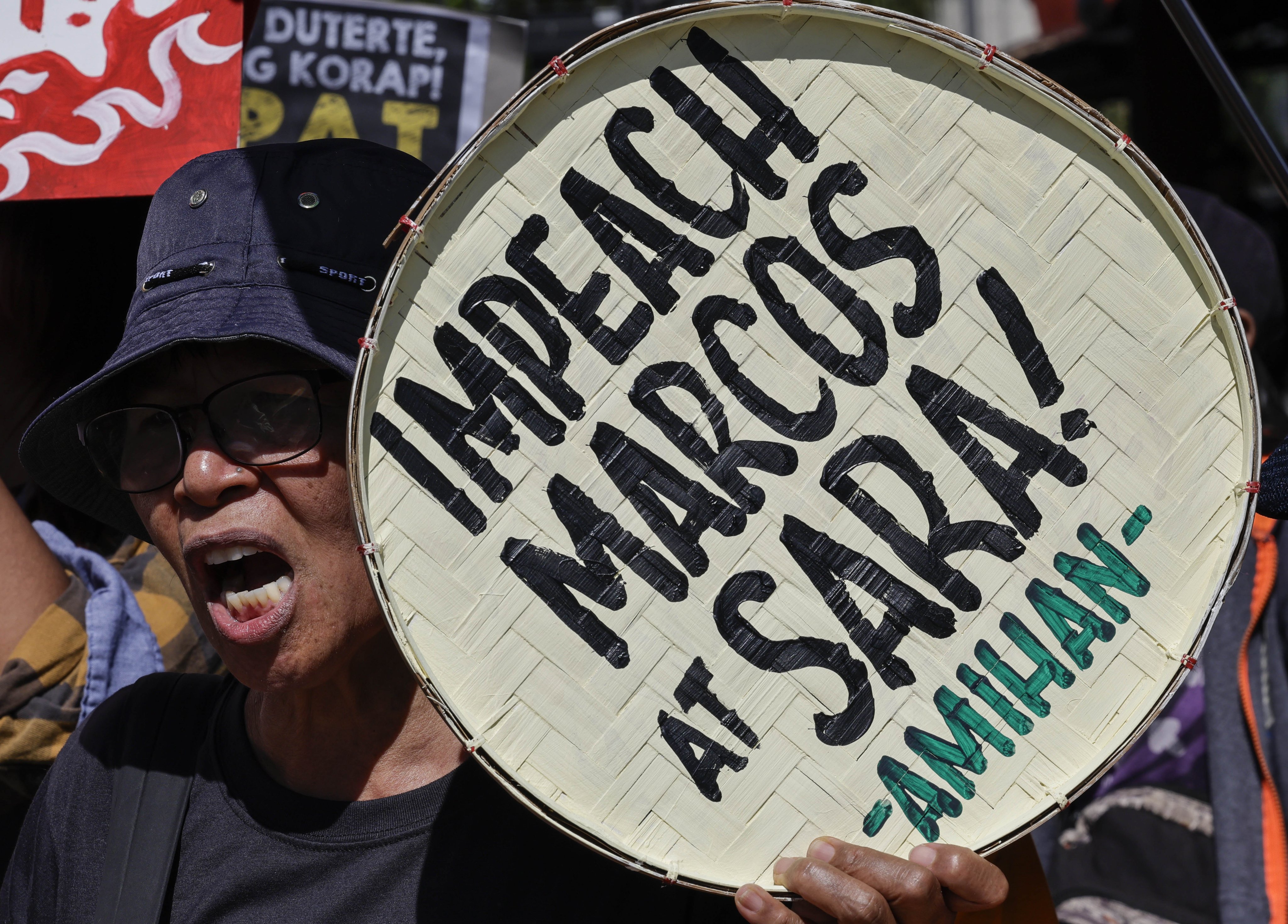 A protester holds a sign calling for the impeachment of Philippine President Ferdinand Marcos Jnr and Vice-President Sara Duterte during a rally outside the House of Representatives in Quezon City on Monday. Photo: EPA