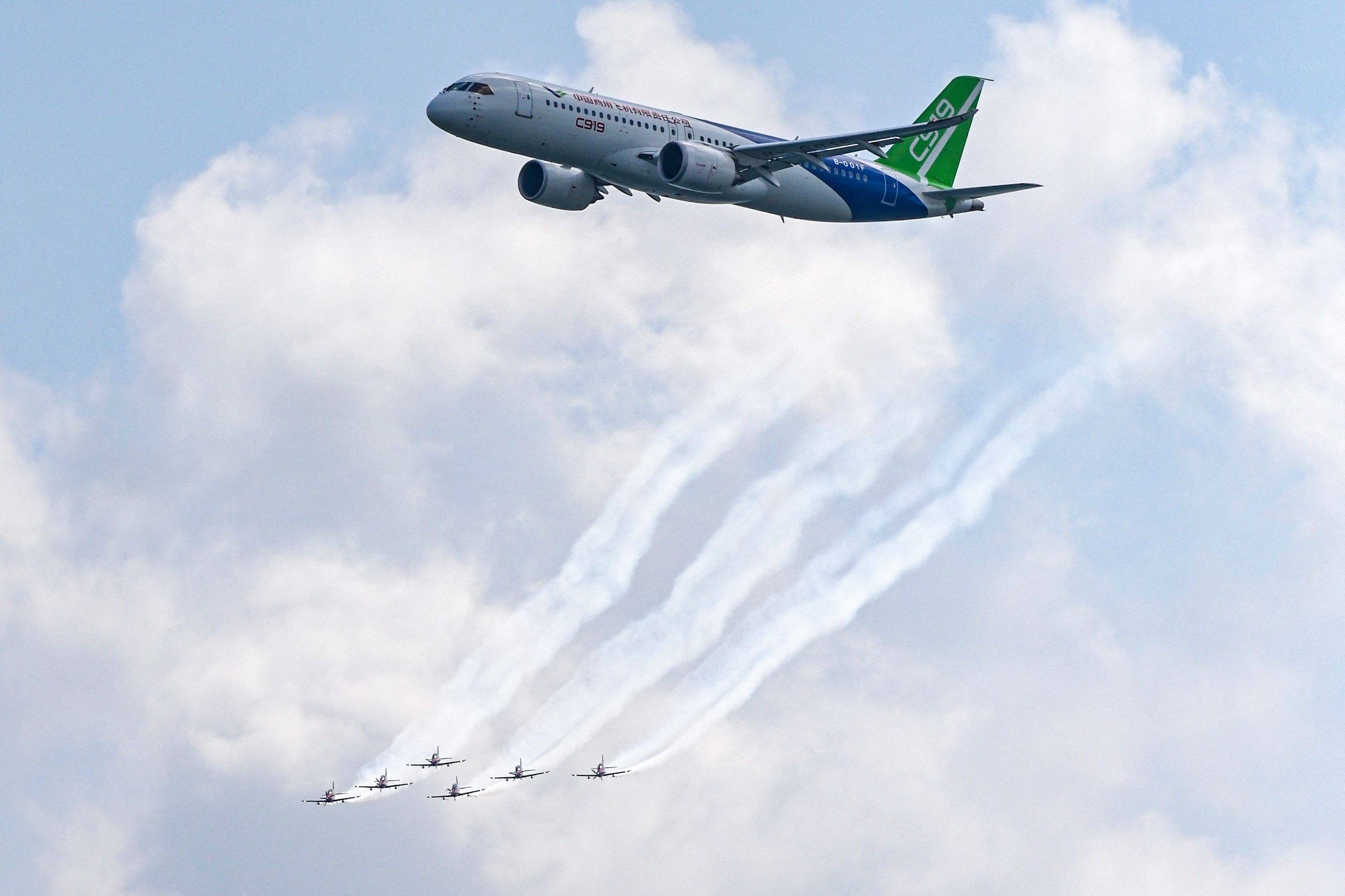 China’s Comac C919 plane, top, and six Pilatus PC-21 aircraft, down, perform during a preview of the 2024 Singapore Airshow in Singapore. Photo: AFP