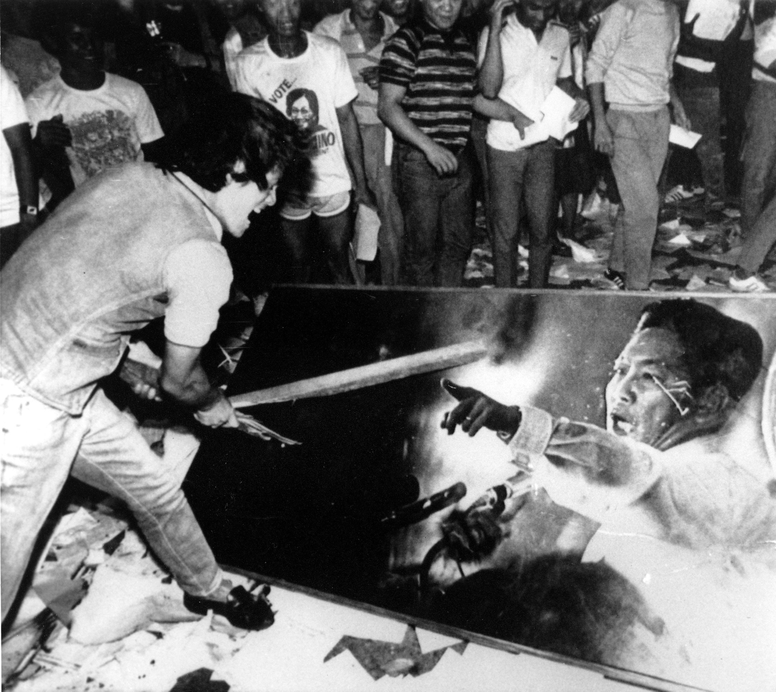 A young protester slashes an oil painting of former Philippine dictator Ferdinand Marcos as looters stormed the presidential palace in Manila following his ouster in February 1986. File photo: AP