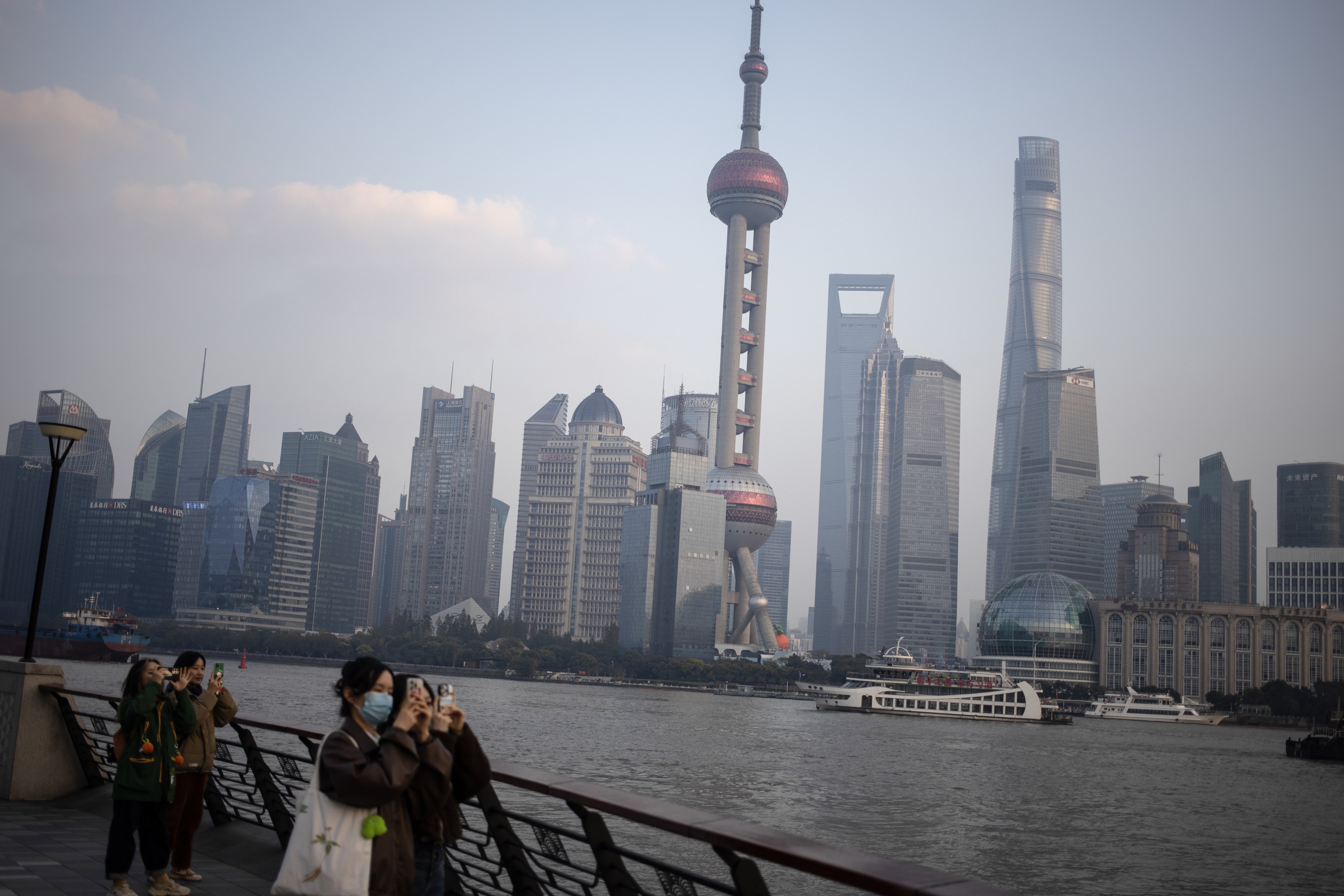 People take pictures at the Bund waterfront area in Shanghai, which is hosting a two-day Finance and Central Bank Deputies’ Meeting. Photo: EPA-EFE