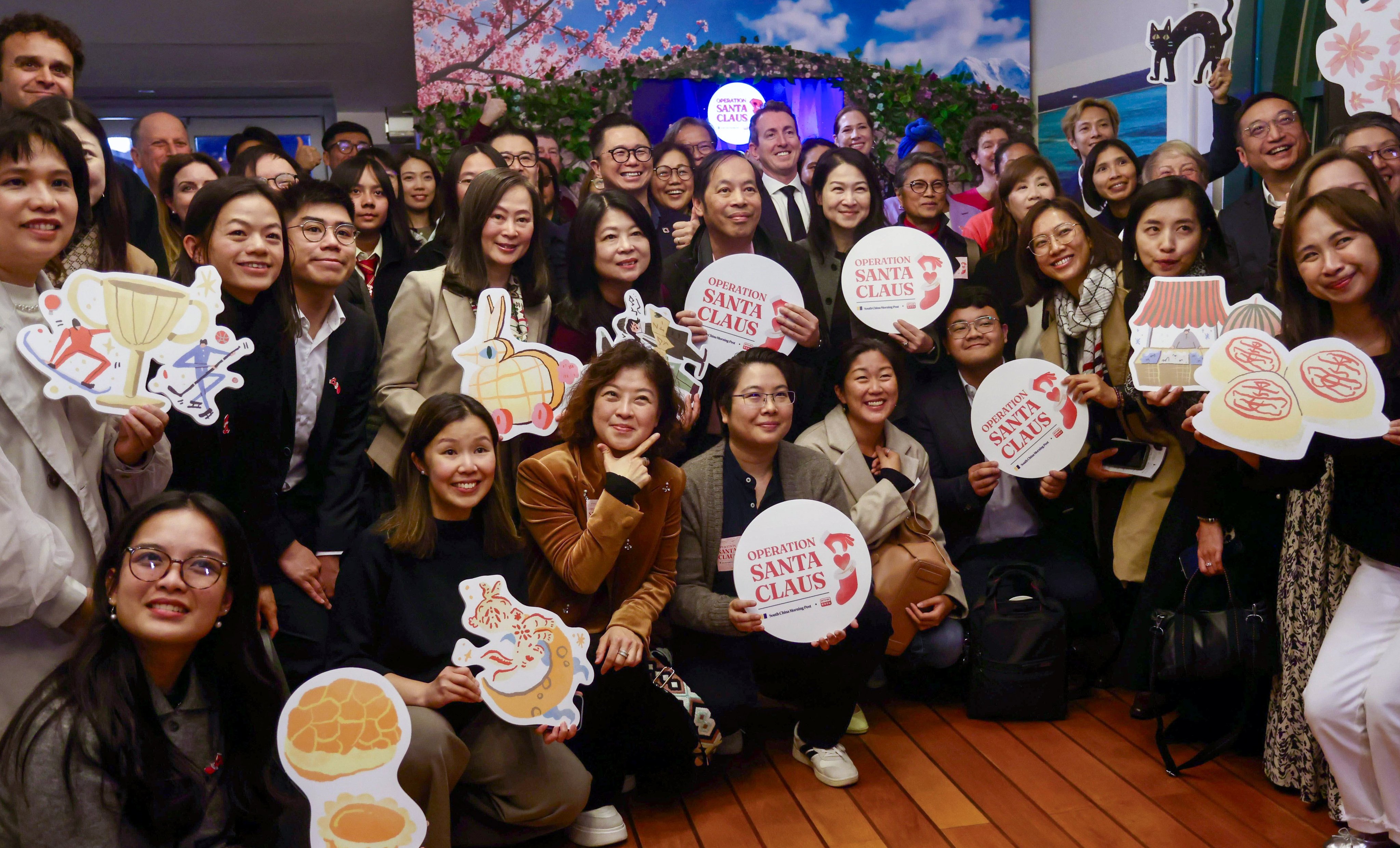 SCMP publisher Tammy Tam and RTHK radio controller Angel Cheng (middle row, third and fourth from left) at the Operation Santa Claus closing ceremony at Cafe 8 on February 3. Photo: Jonathan Wong