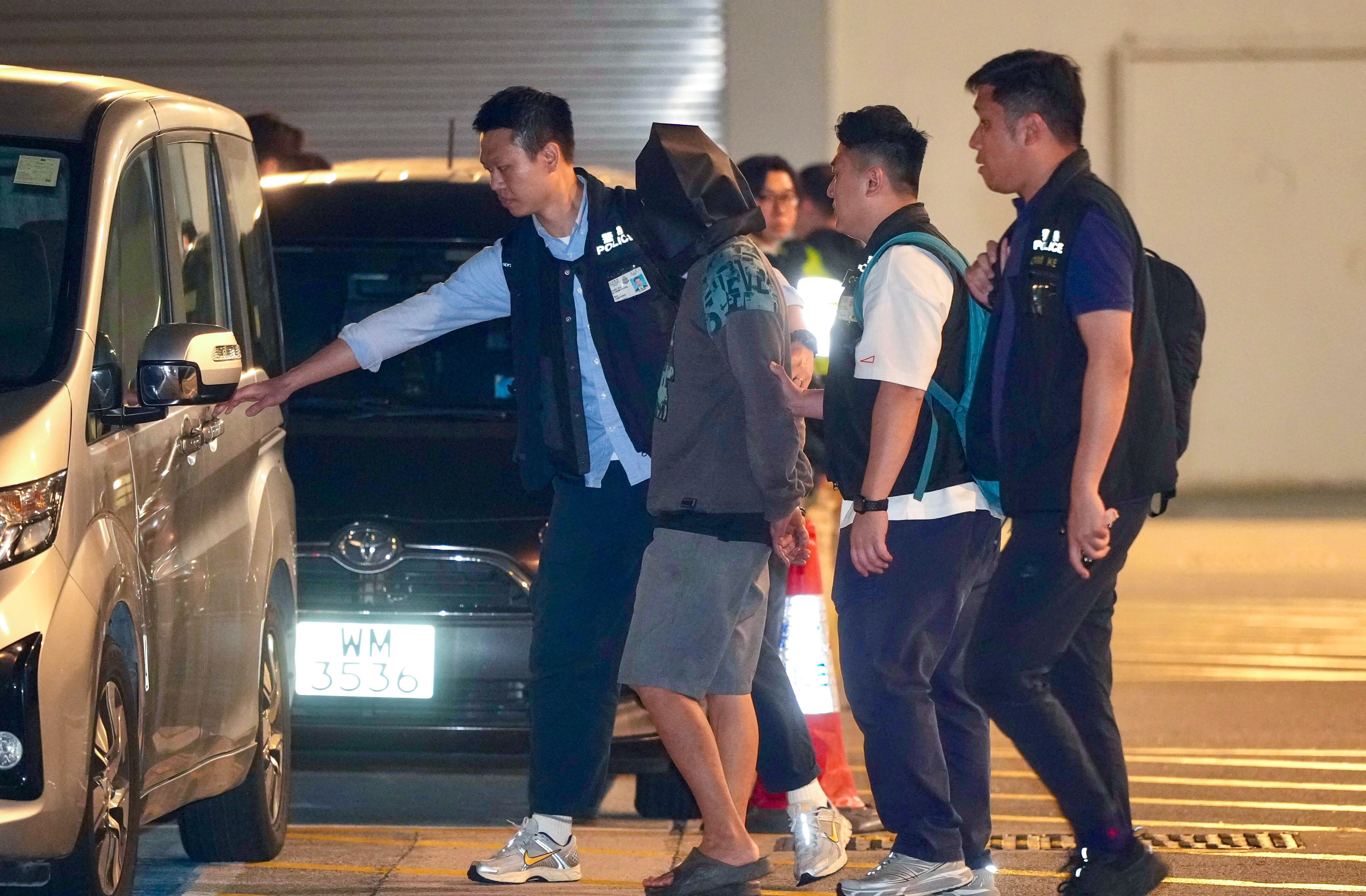 Officers escort the murder suspect to the Airport Police Station in Hong Kong. Photo: Sam Tsang