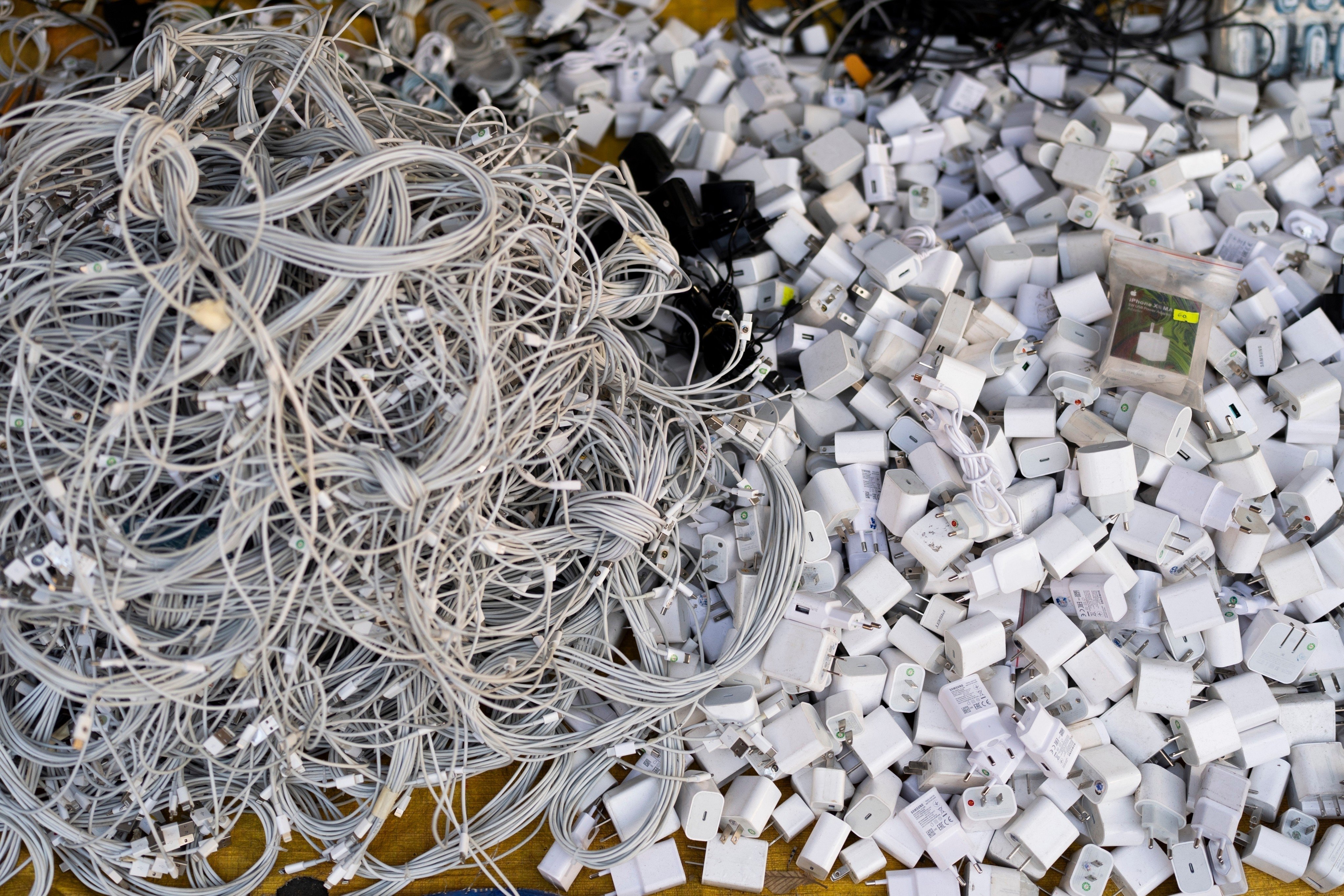 Used charging cables and power adapters are piled up at a shop in Nhat Tao market, Vietnam. Photo: AP