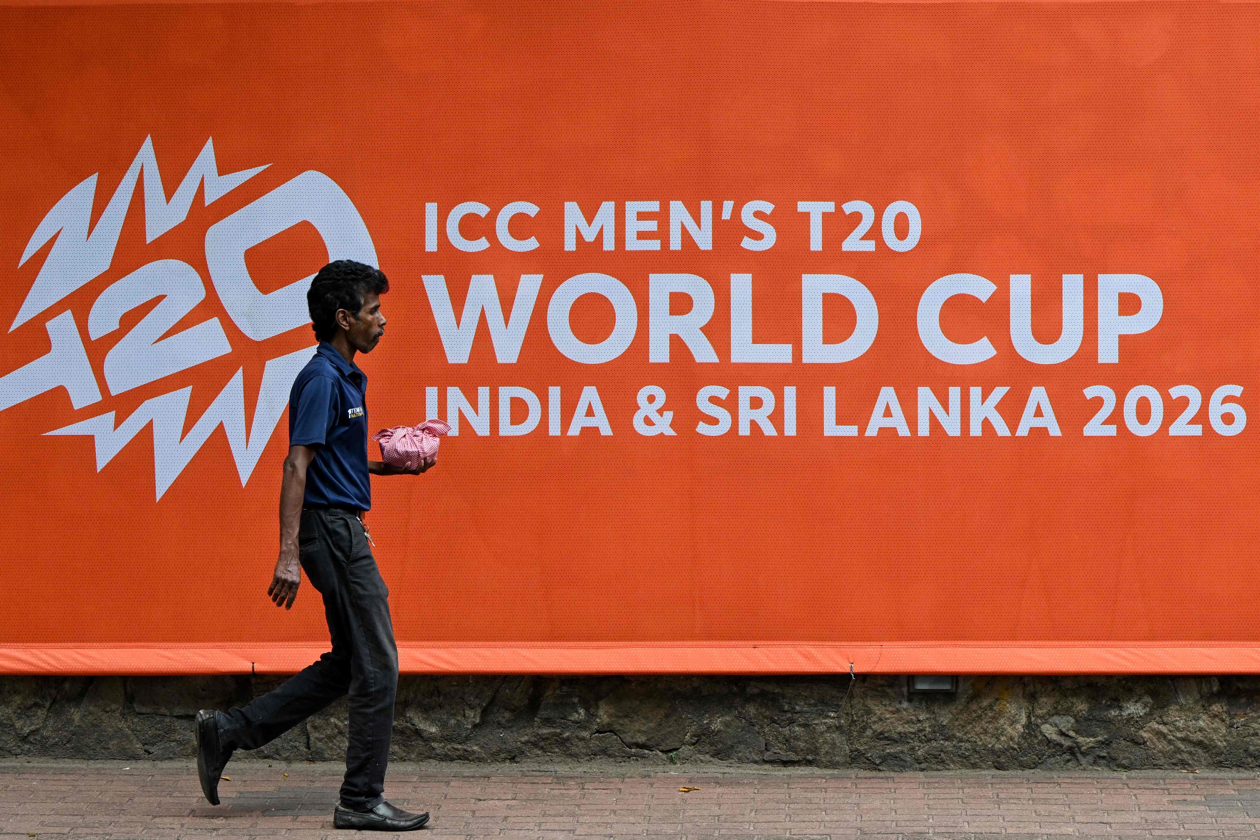 A man walks past a billboard advertising the 2026 Men’s T20 Cricket World Cup at the Sinhalese Sports Club cricket stadium in Colombo on Thursday. Photo: AFP