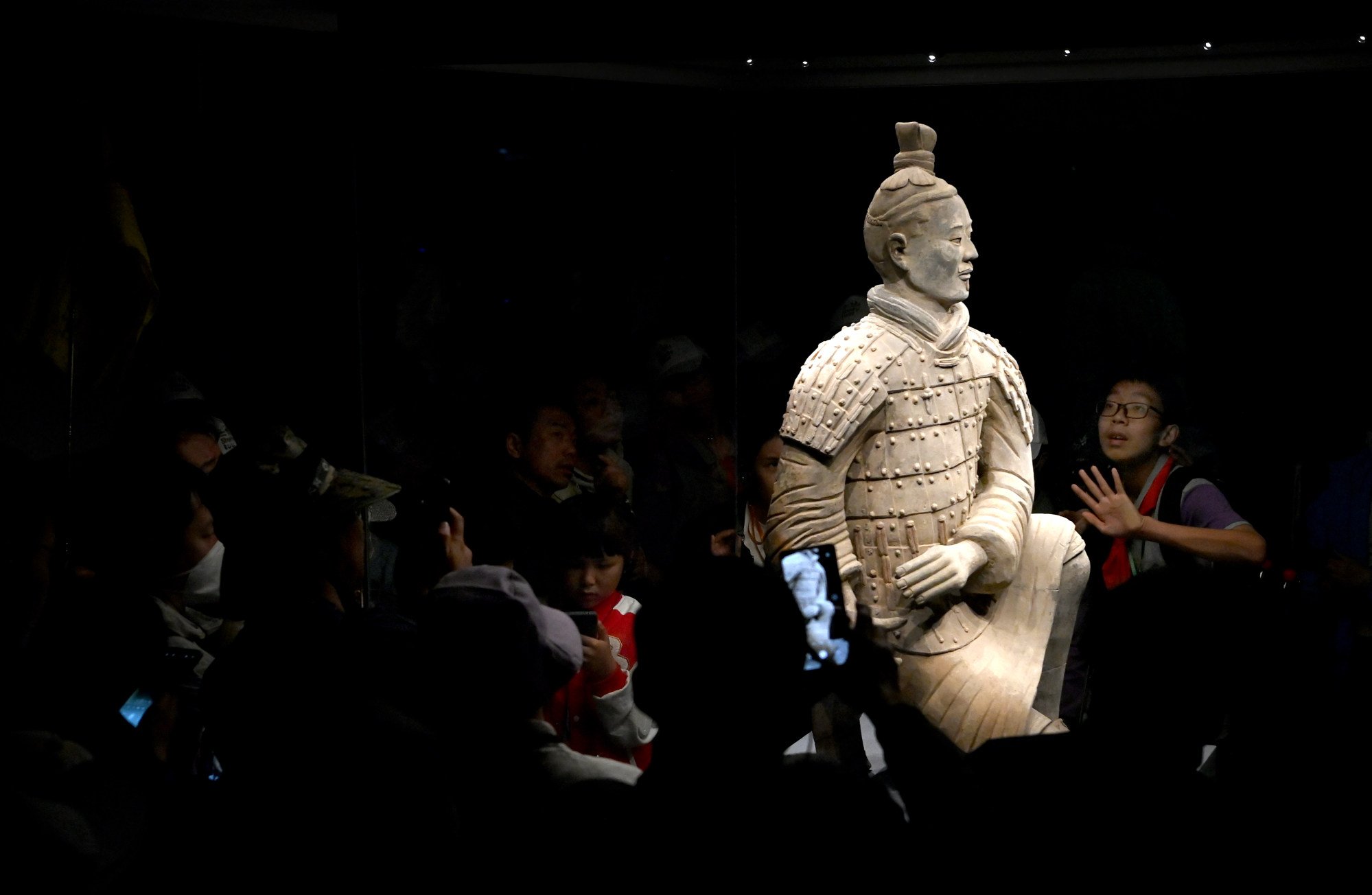 A lone and floodlit Qin terracotta warrior impresses a young visitor at the Xian site. Photo: Xinhua A lone and floodlit Qin terracotta warrior impresses a young visitor at the Xian site. Photo: Xinhua