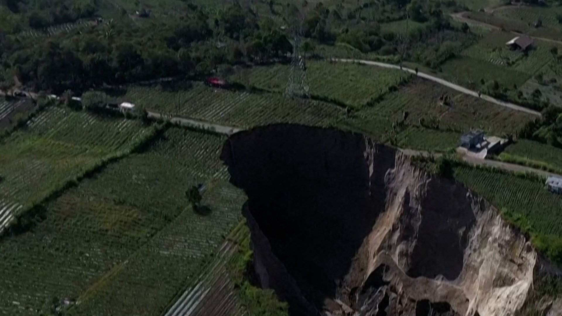 A 100-metre-deep sinkhole has slowly swallowed part of a village in northwestern Indonesia.