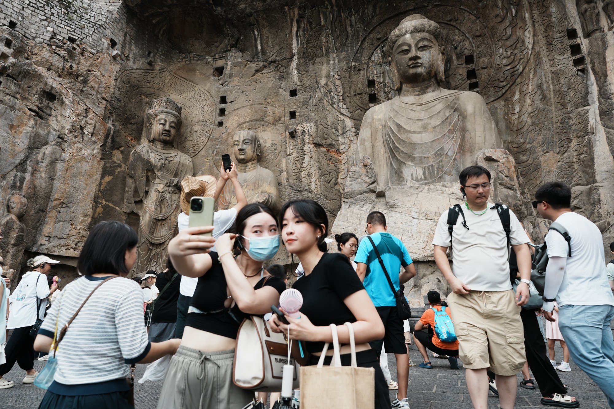 Tourists take a selfie with the Vairocana Buddha at Longmen Grottoes, a Unesco World Heritage site in China’s Henan province. Photo: Getty Images Tourists take a selfie with the Vairocana Buddha at Longmen Grottoes, a Unesco World Heritage site in China’s Henan province. Photo: Getty Images