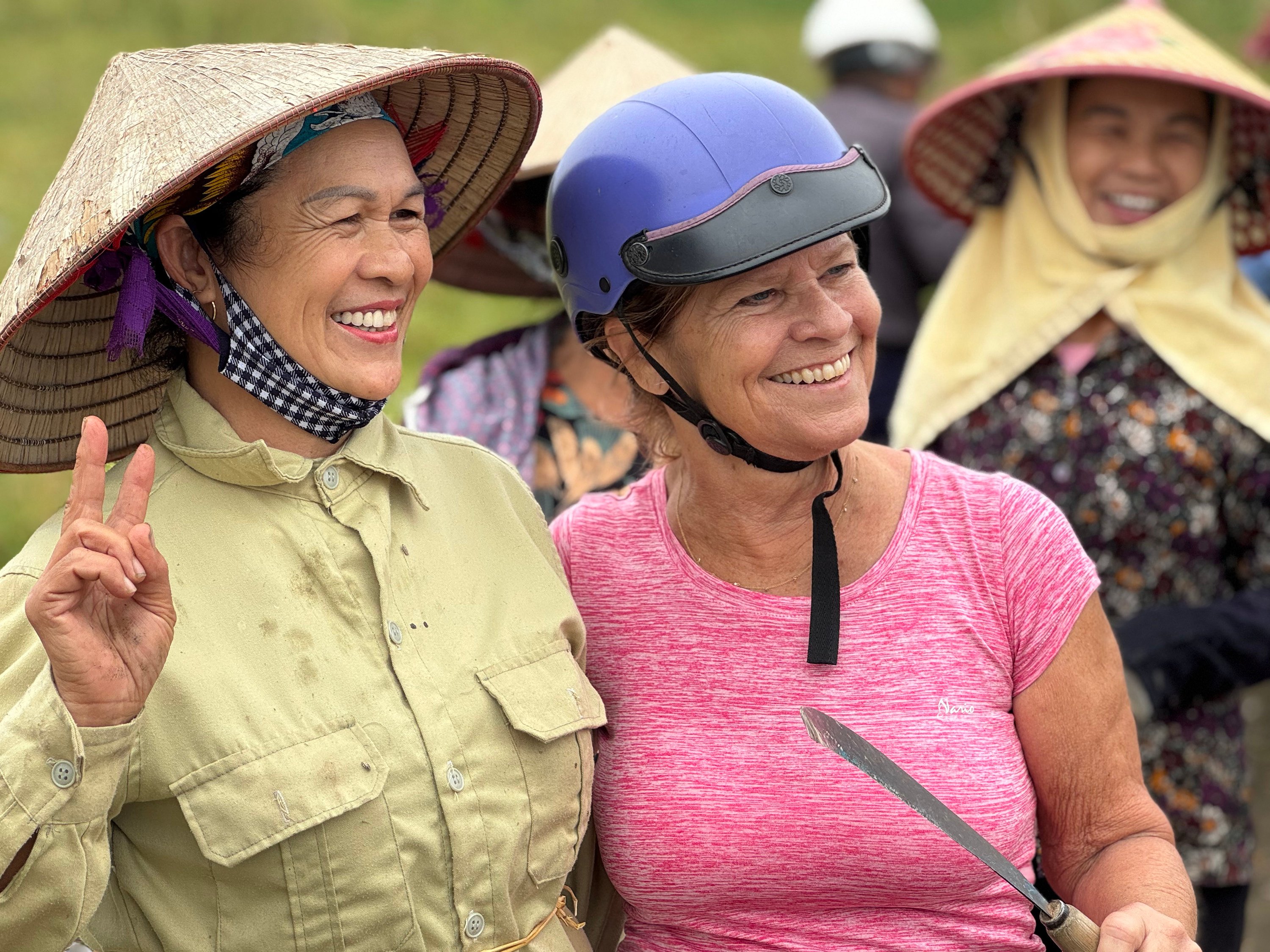 A member of an AdventureWomen tour poses for a photo with women working in rice paddies in northern Vietnam. Photo: TNS