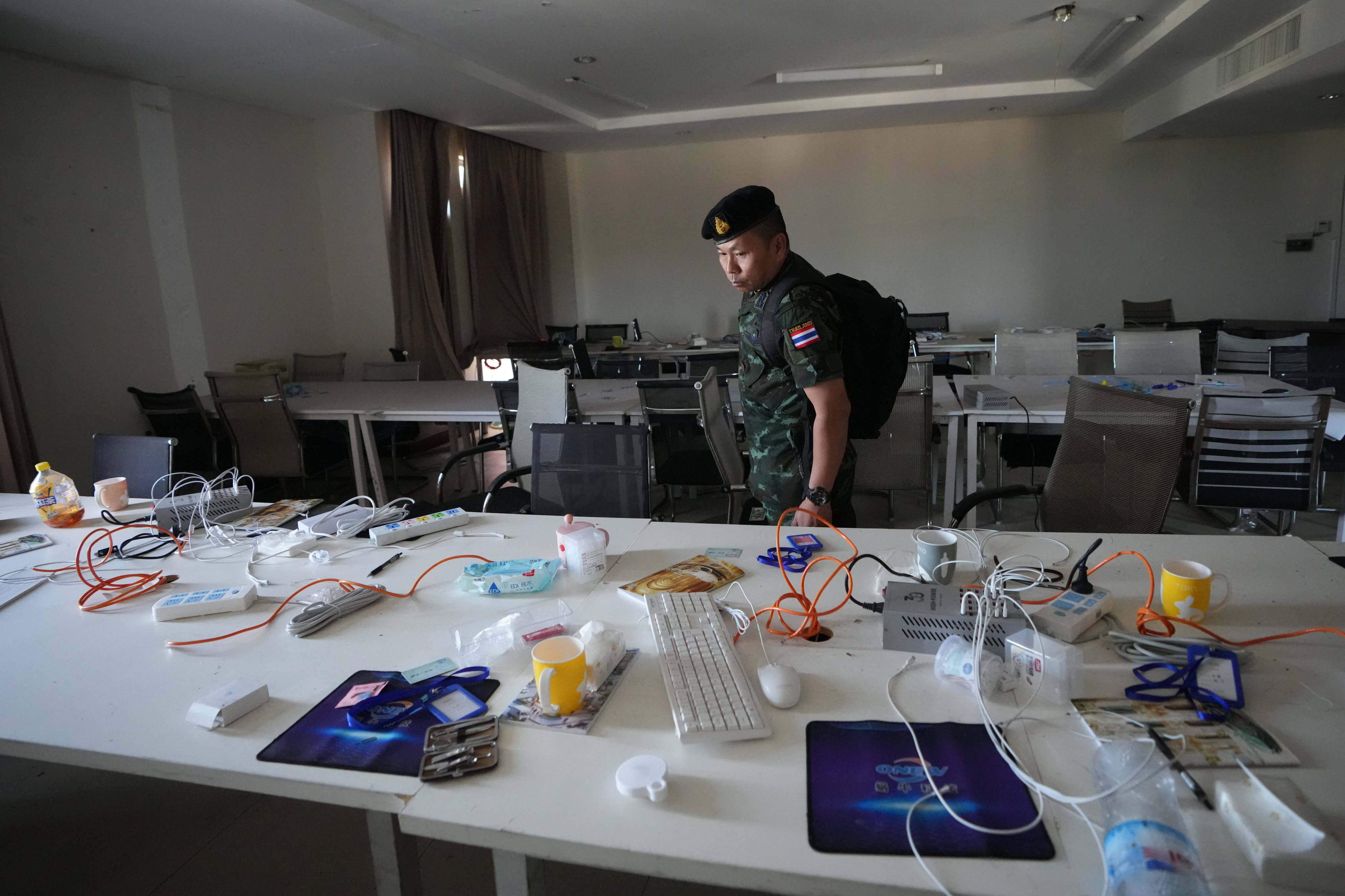 A Thai solider inspects a workstation inside a scam centre in O’Smach, Cambodia, on Monday. Photo: AP