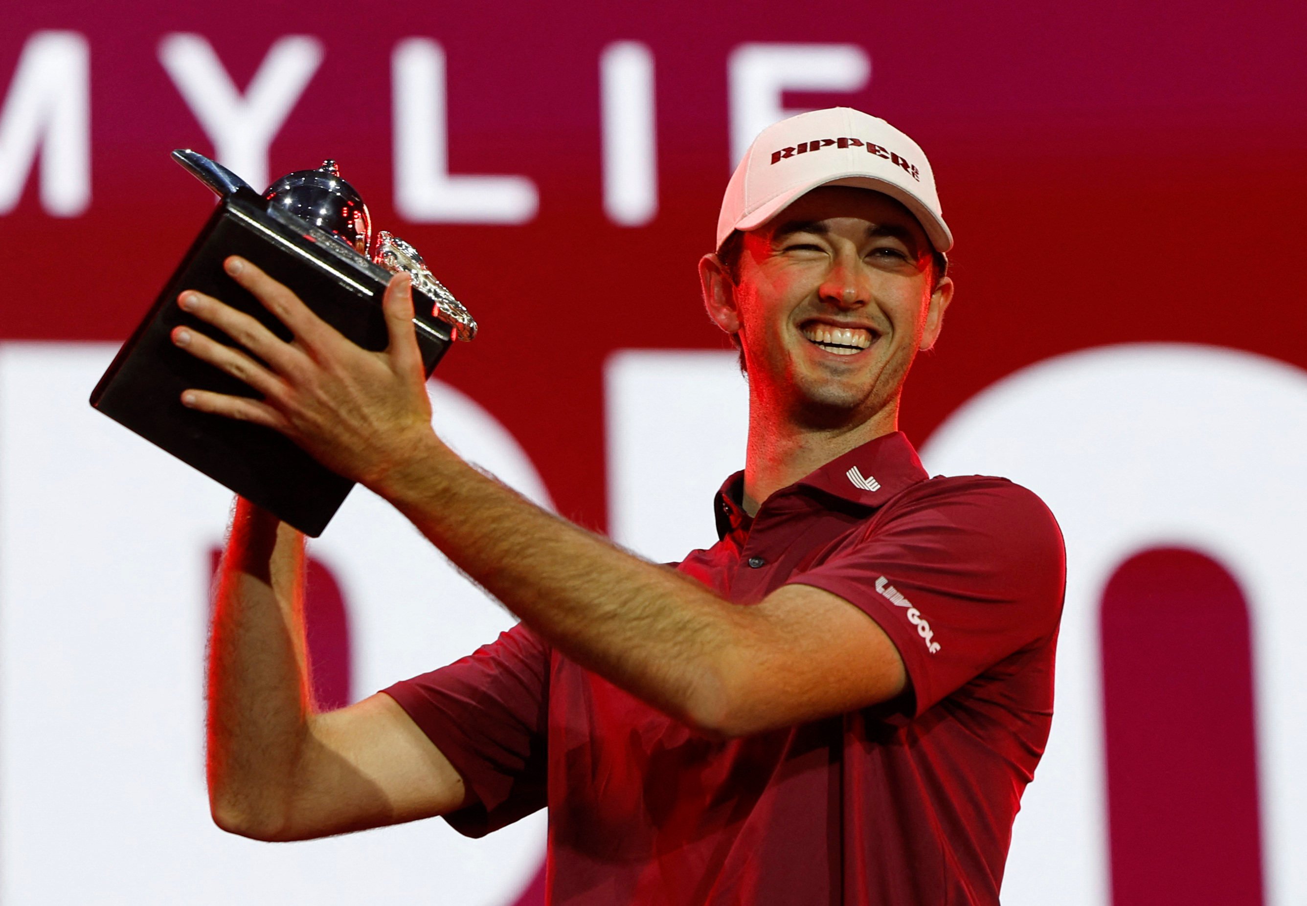 Elvis Smylie celebrates with the LIV Golf Riyadh trophy after pipping Jon Rahm to the title. Photo: Reuters
