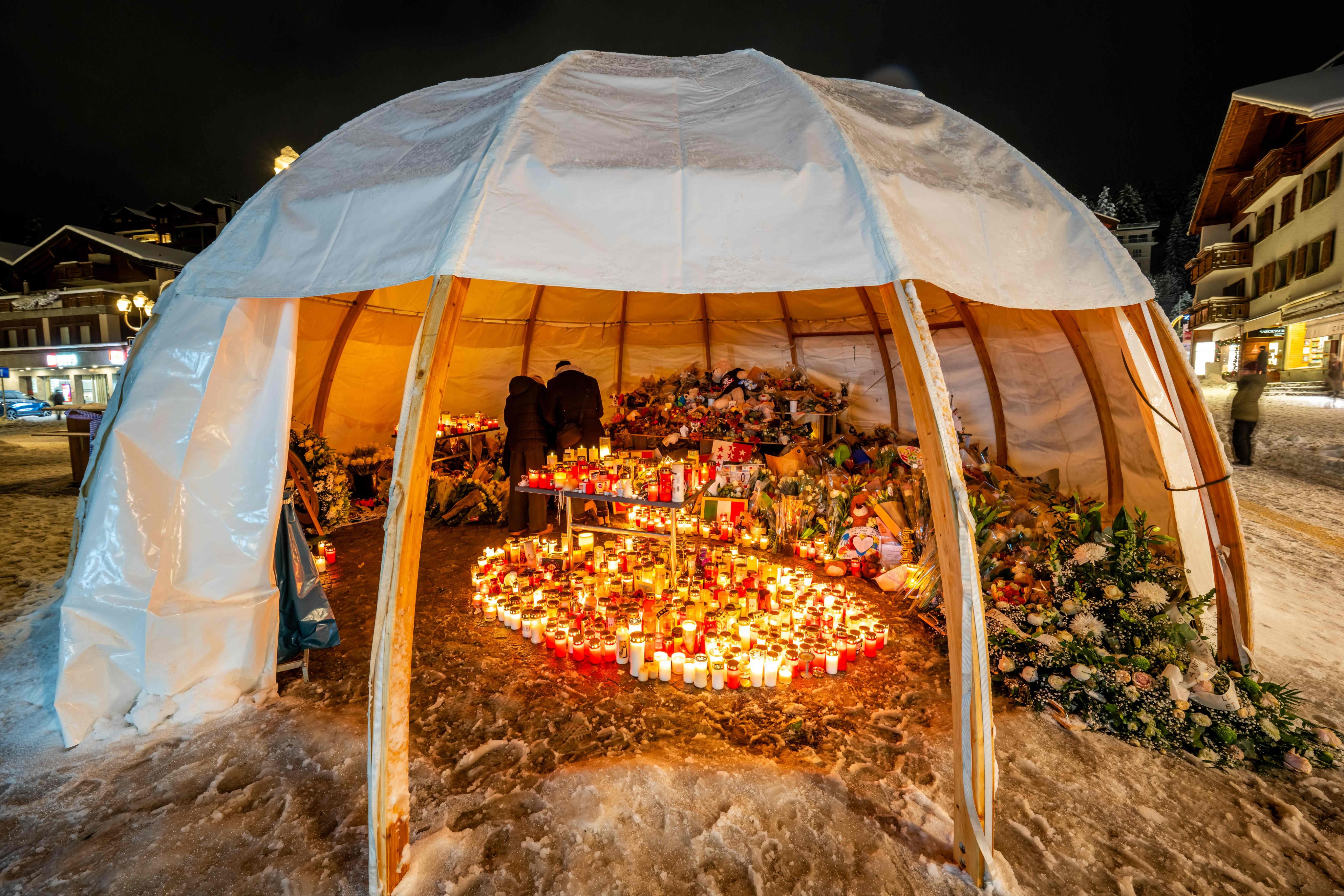 Mourners place messages, candles, and flowers at a memorial outside Le Constellation bar during a national day of mourning in Crans-Montana, Switzerland on January 9. Photo: AFP