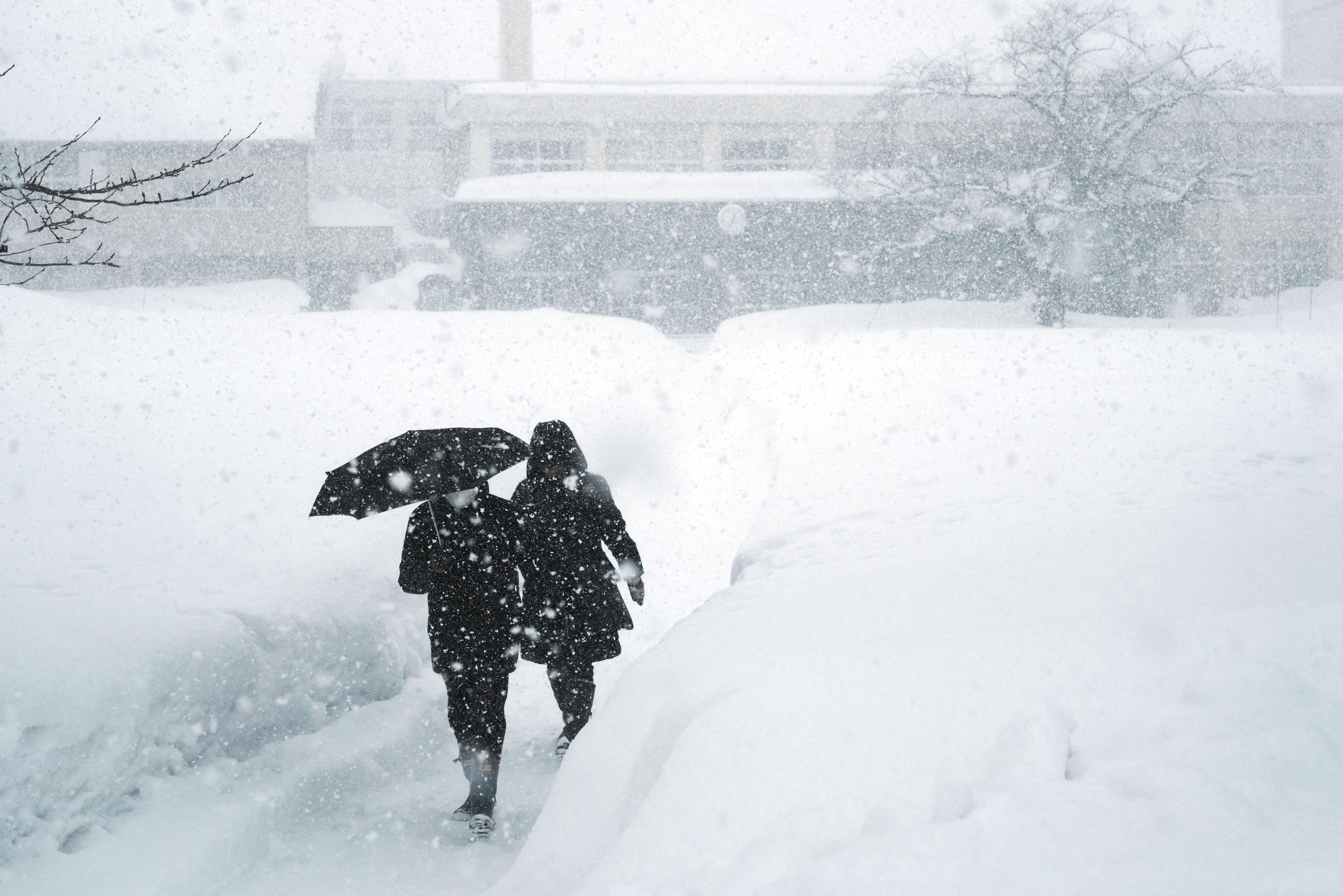 People walk along a snow-covered road after leaving a polling station for the general election, in Aomori, Aomori prefecture, on Sunday. Photo: Kyodo via Reuters