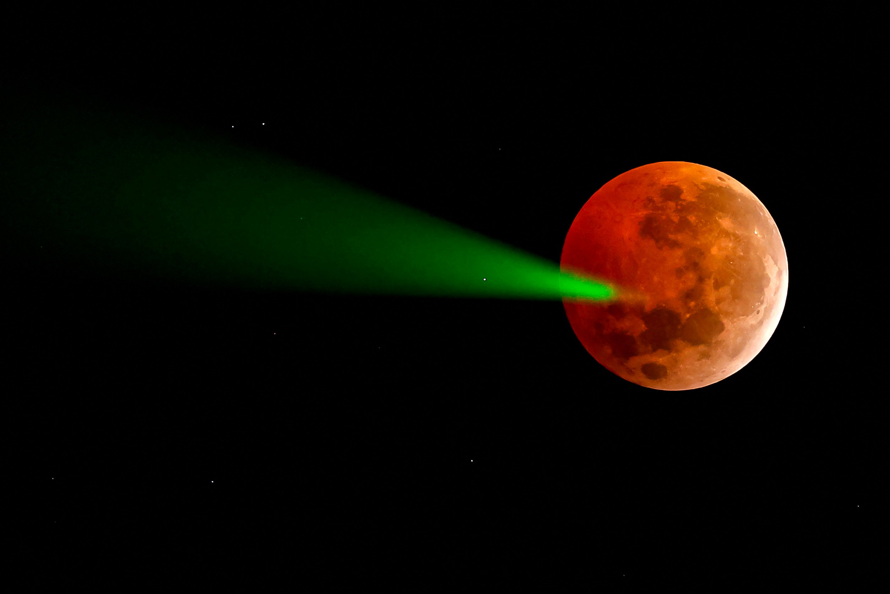 A full moon eclipse being targeted with a laser from the Foster Observatory telescope in Santiago, Chile in 2025. Photo: AFP