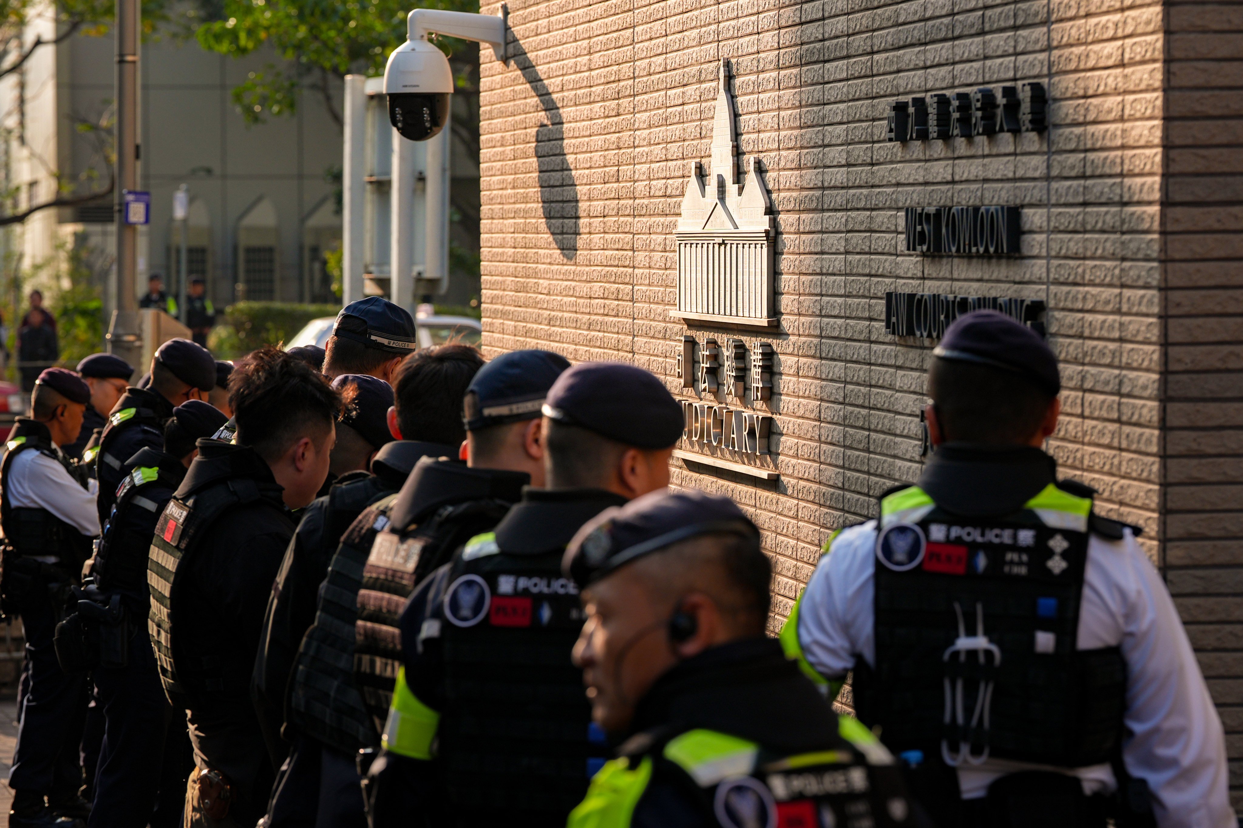 Police officers stand guard outside West Kowloon Court on Monday morning as former media boss Jimmy Lai is sentenced to 20 years in prison. Photo: Eugene Lee