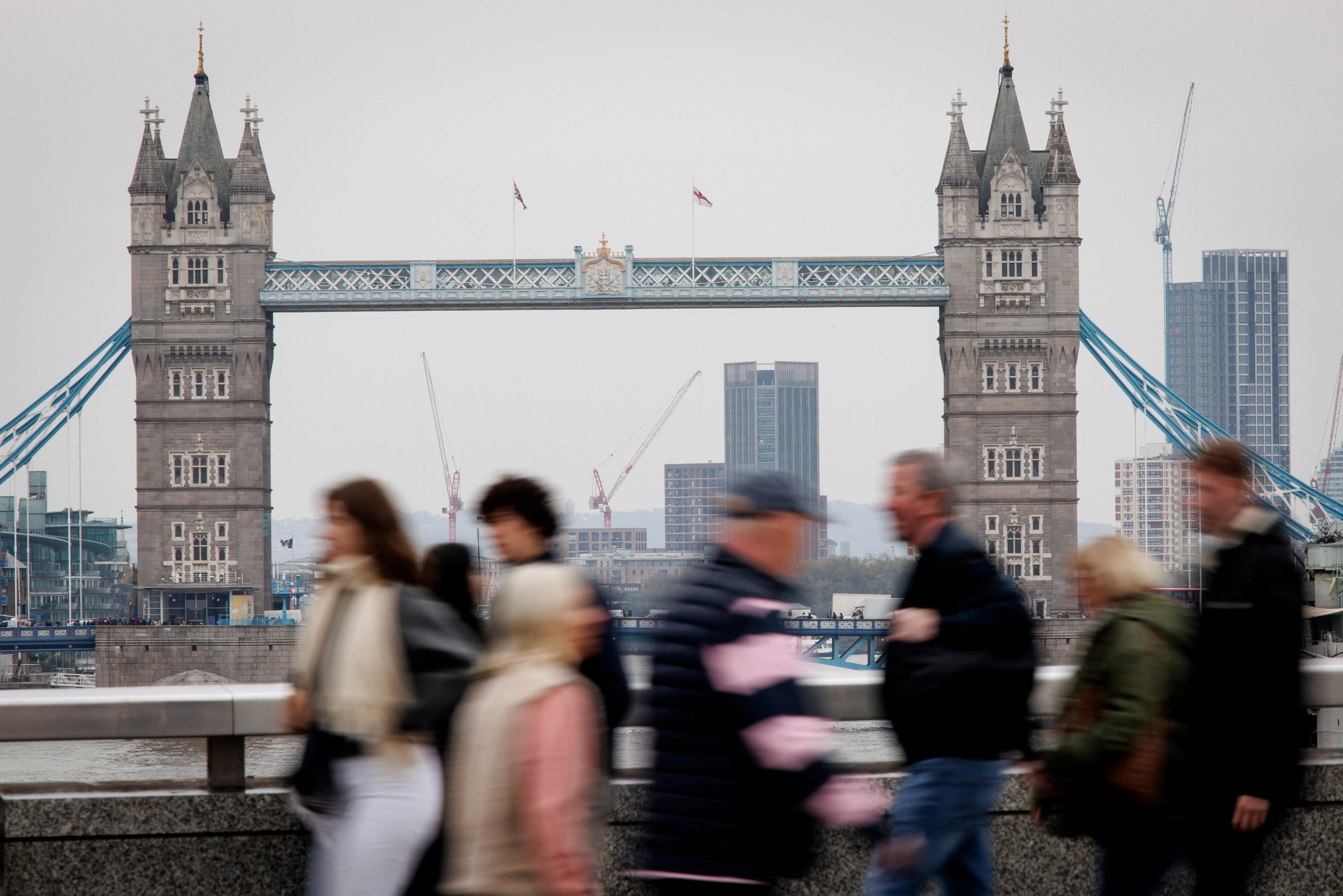 People cross London Bridge, with Tower Bridge in the background, in London in 2024. Photo: EPA-EFE