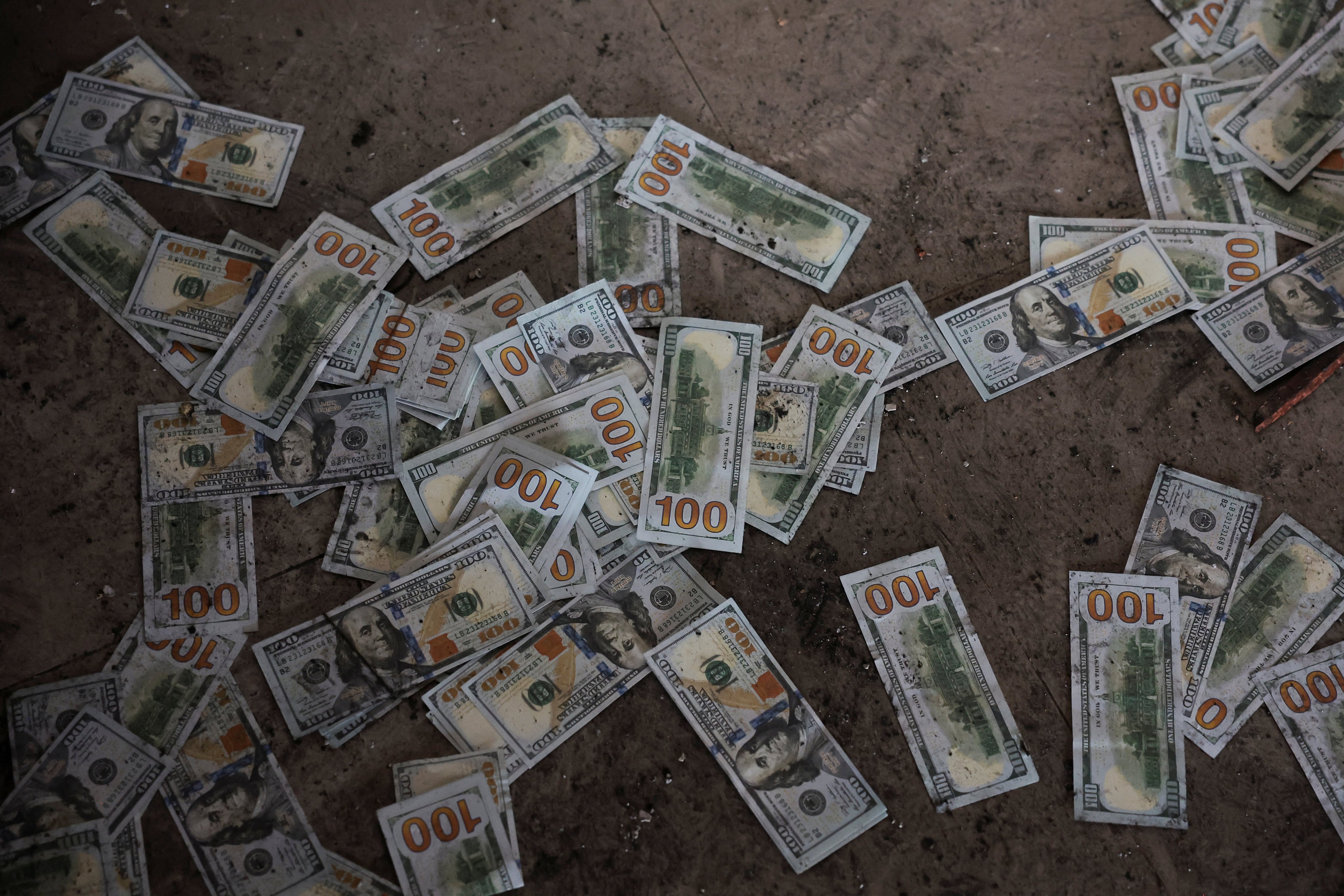 Counterfeit US dollar banknotes on the floor inside a scam compound in Samraong, Cambodia’s Oddar Meanchey province. Photo: Reuters