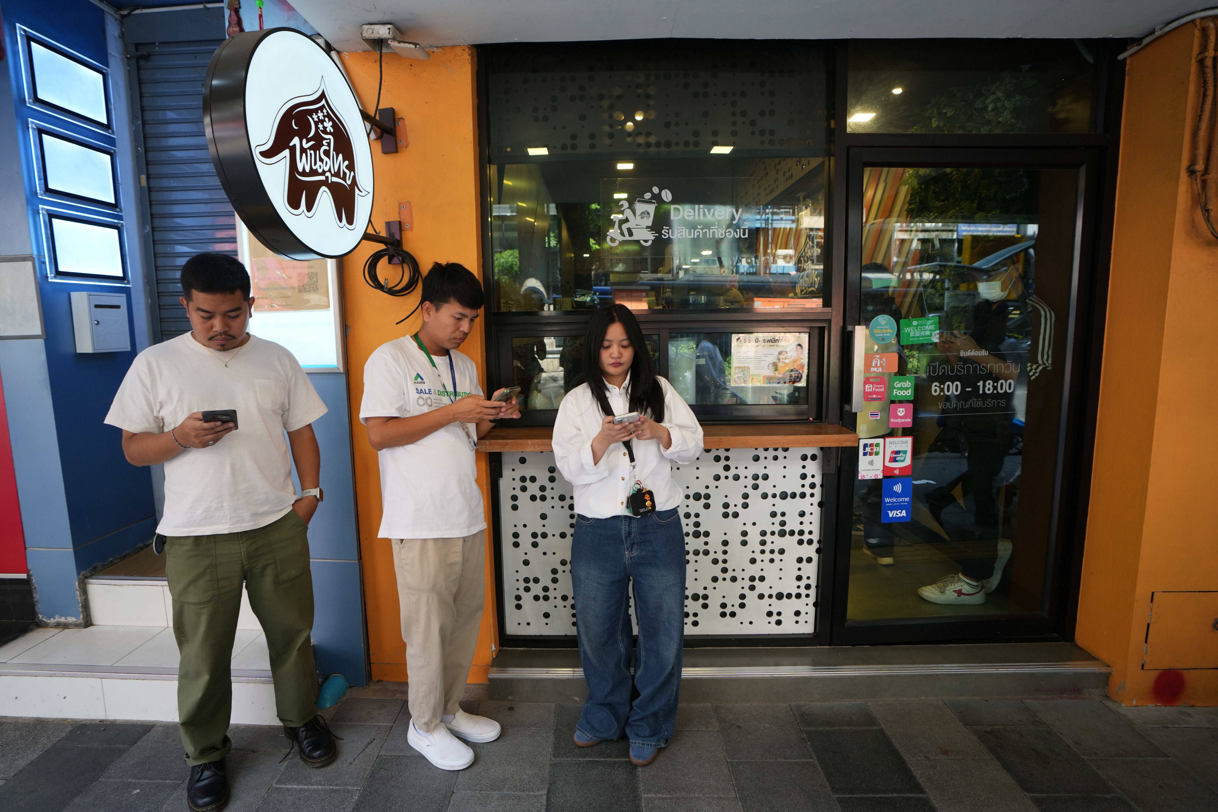 Customers wait for their coffee outside a coffee shop in Bangkok, Thailand on Wednesday. Photo: AP