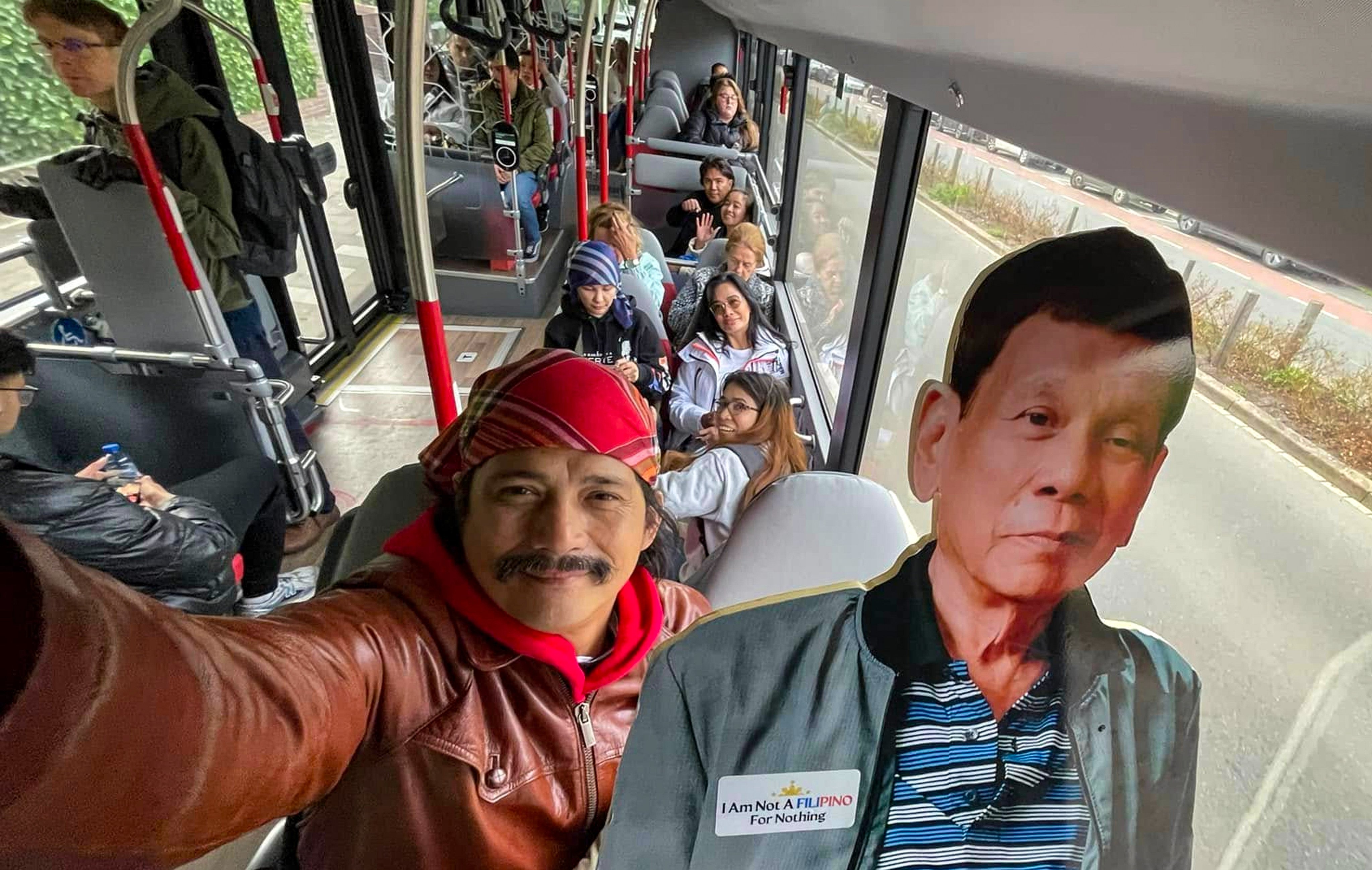 Philippine Senator Robin Padilla carrying a cardboard cutout of ex-president Rodrigo Duterte on a bus. Photo: handout
