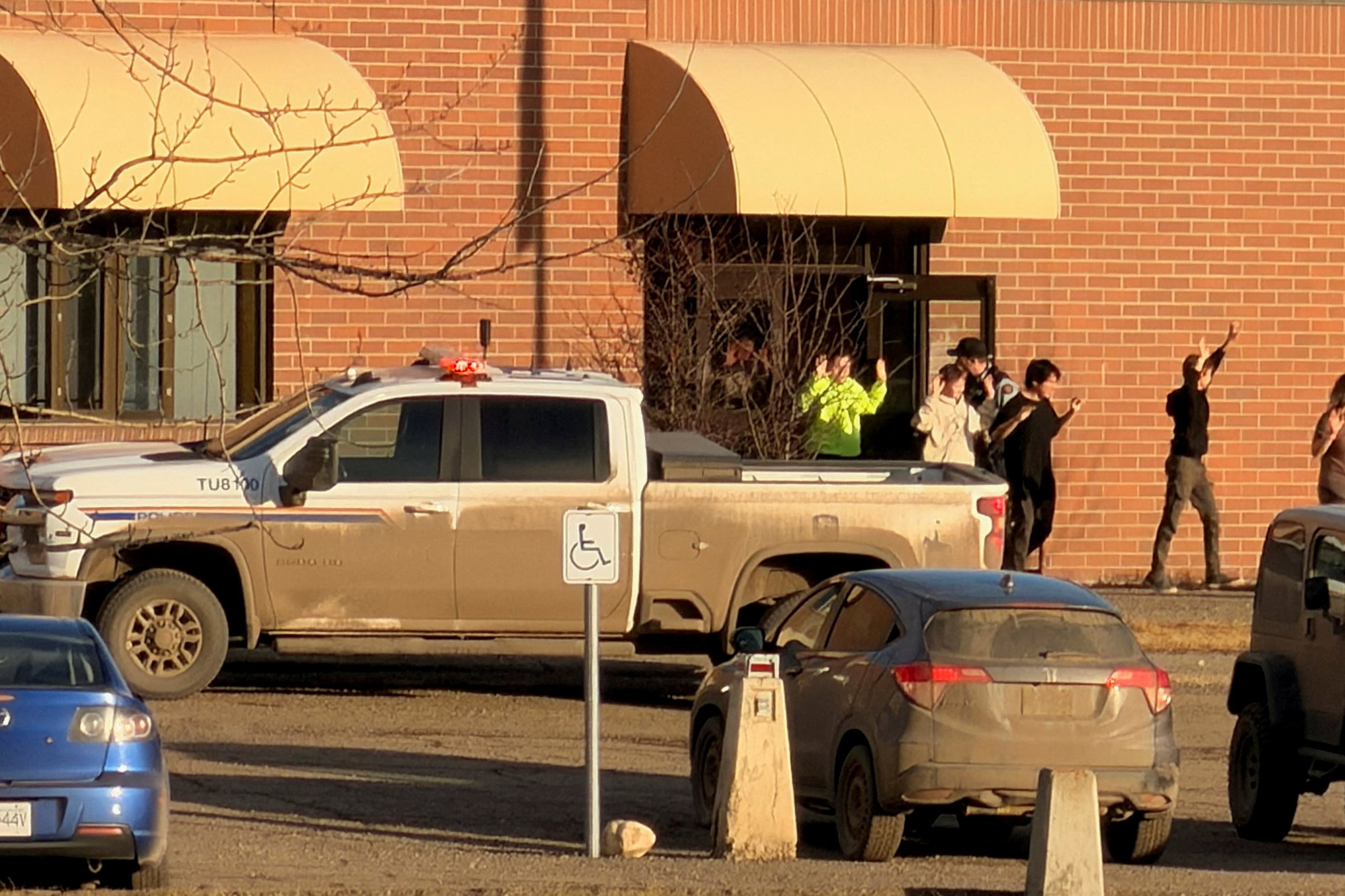 Police escort students out of their school in Tumbler Ridge after the shooting. Photo: Western Standard via Reuters