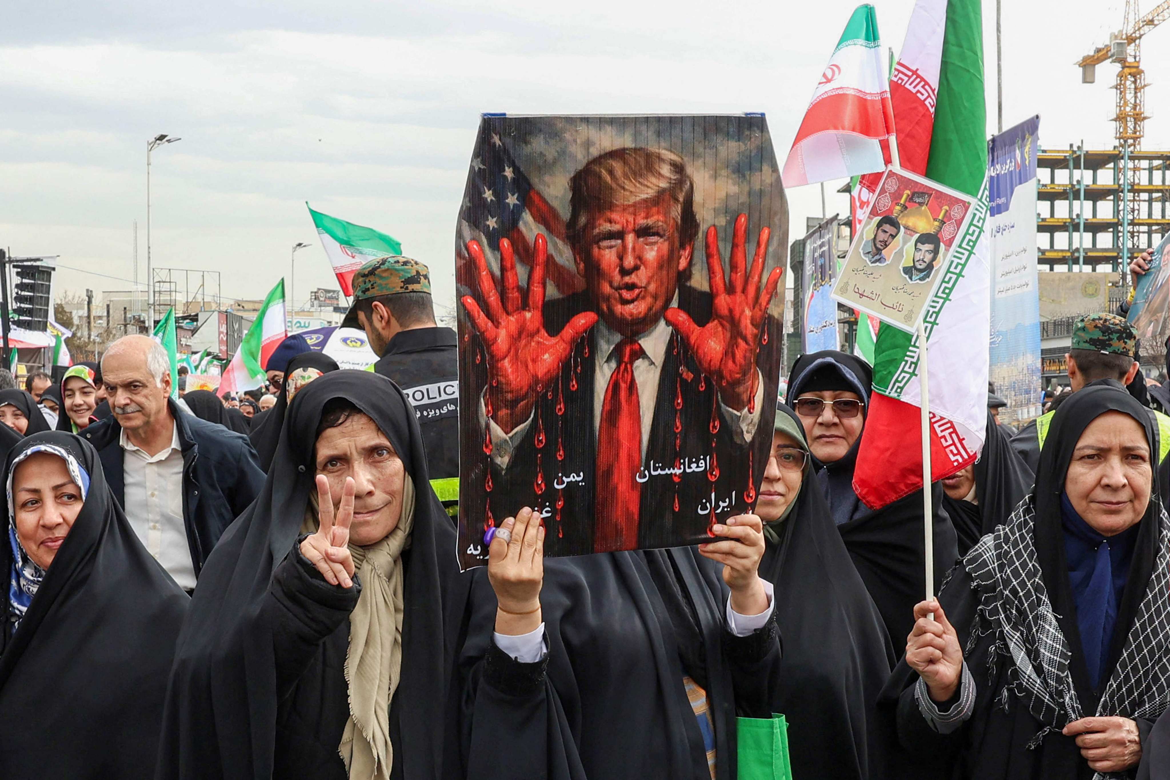 Women march with a sign depicting US President Donald Trump with bloodied hands in Tehran on Wednesday during a rally marking the  anniversary of the 1979 Islamic revolution. Photo: AFP
