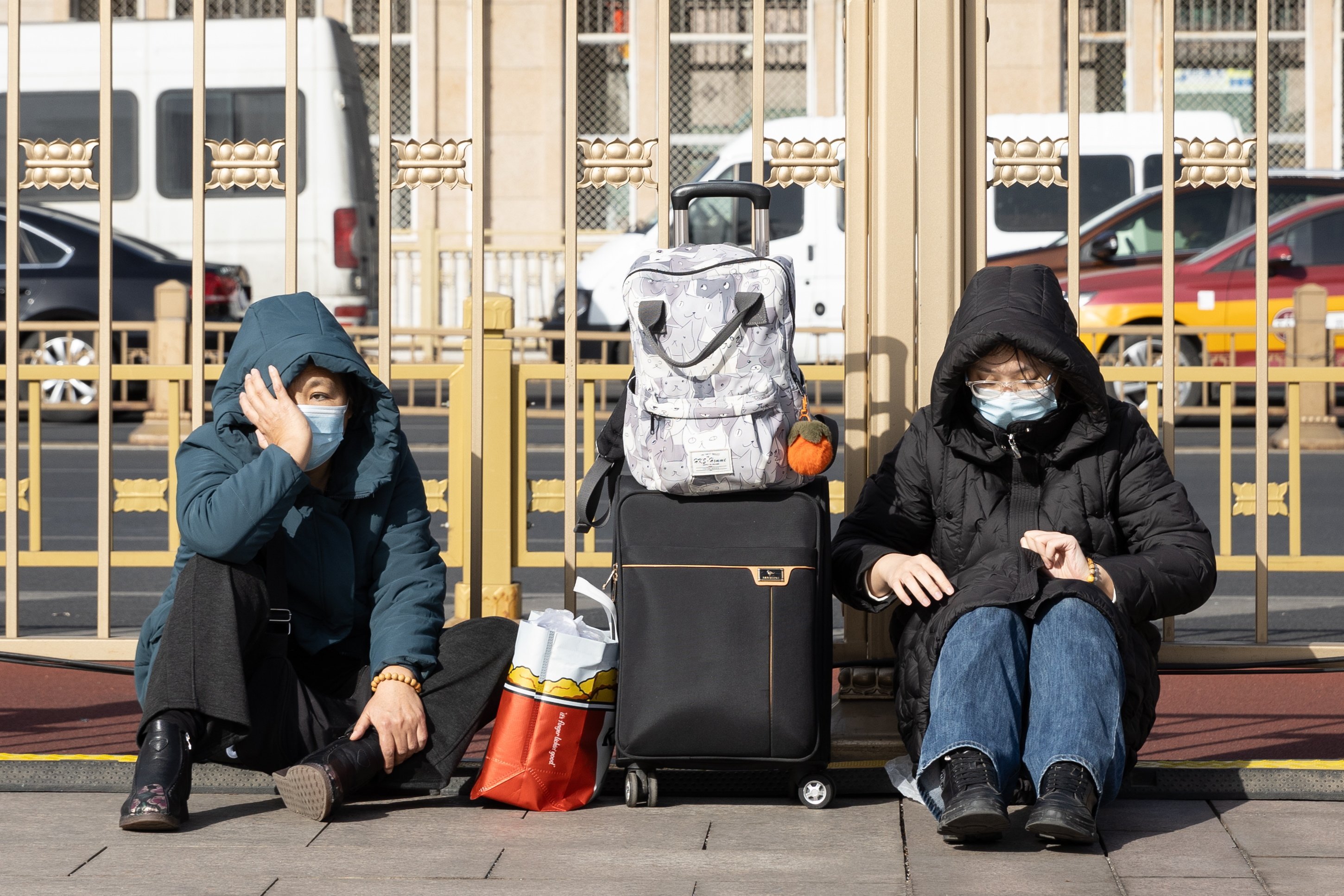 Travelers wait with their luggage outside a train station in Beijing on February 10, 2026. Photo: EPA