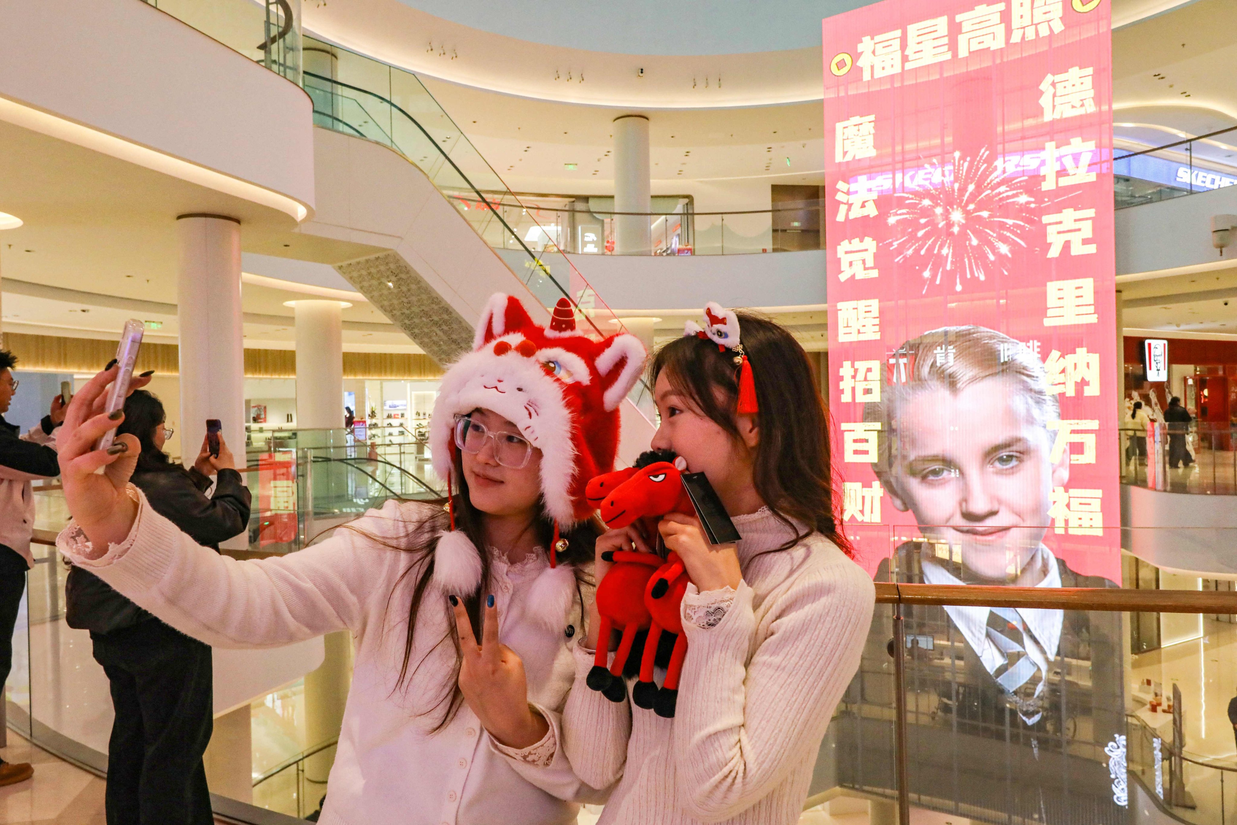 Shoppers take a selfie in front of a poster featuring Tom Felton as his Harry Potter character Draco Malfoy at a mall in Shangqiu, in China’s central Henan province. Find out more about how the Year of the Horse influences Chinese culture, from fireworks to linguistics, and why Draco Malfoy is an unexpected Lunar New Year icon. Photo: AFP