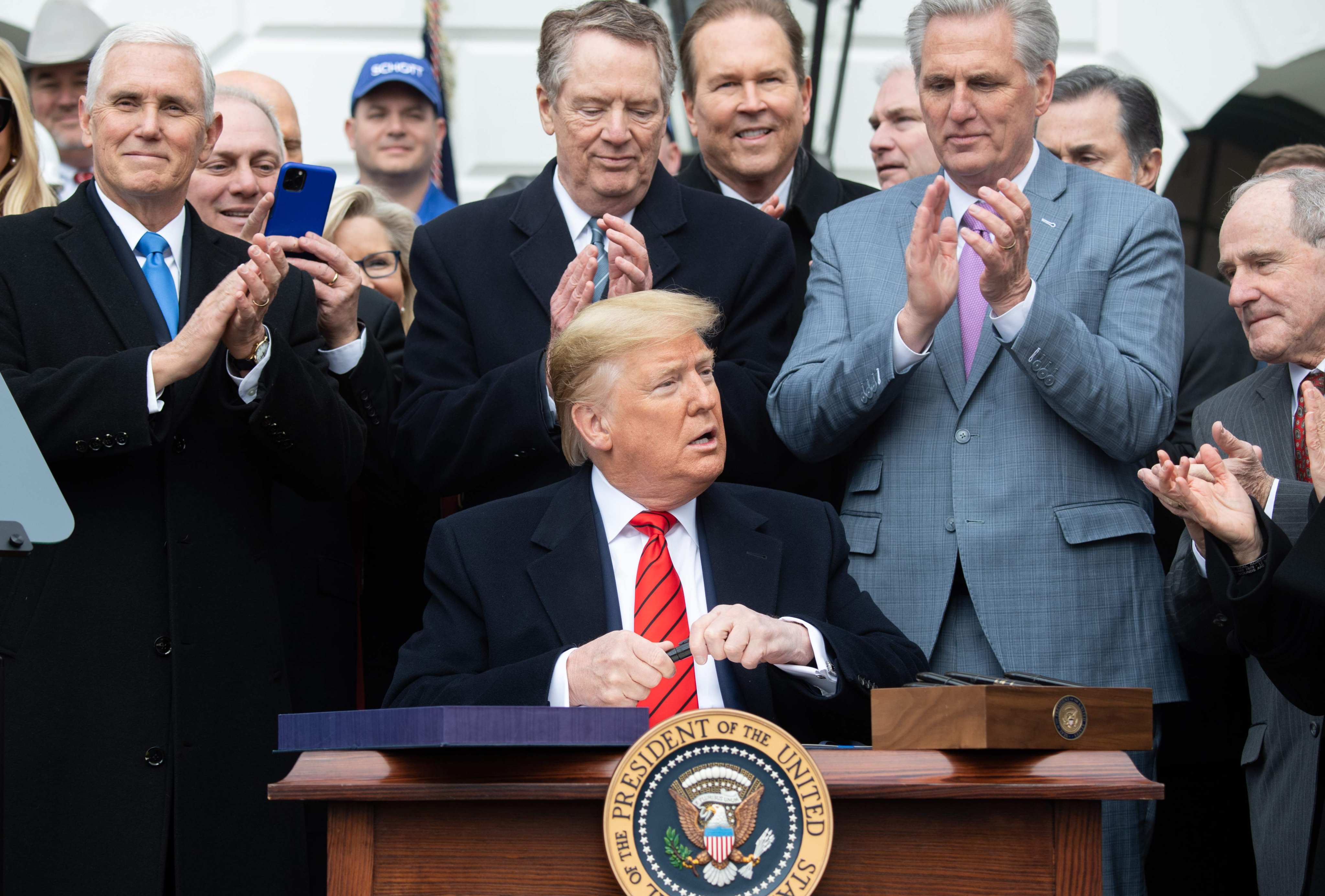 US President Donald Trump signs the USMCA trade agreement during a ceremony on the South Lawn of the White House in Washington in January 2020. Photo: AFP