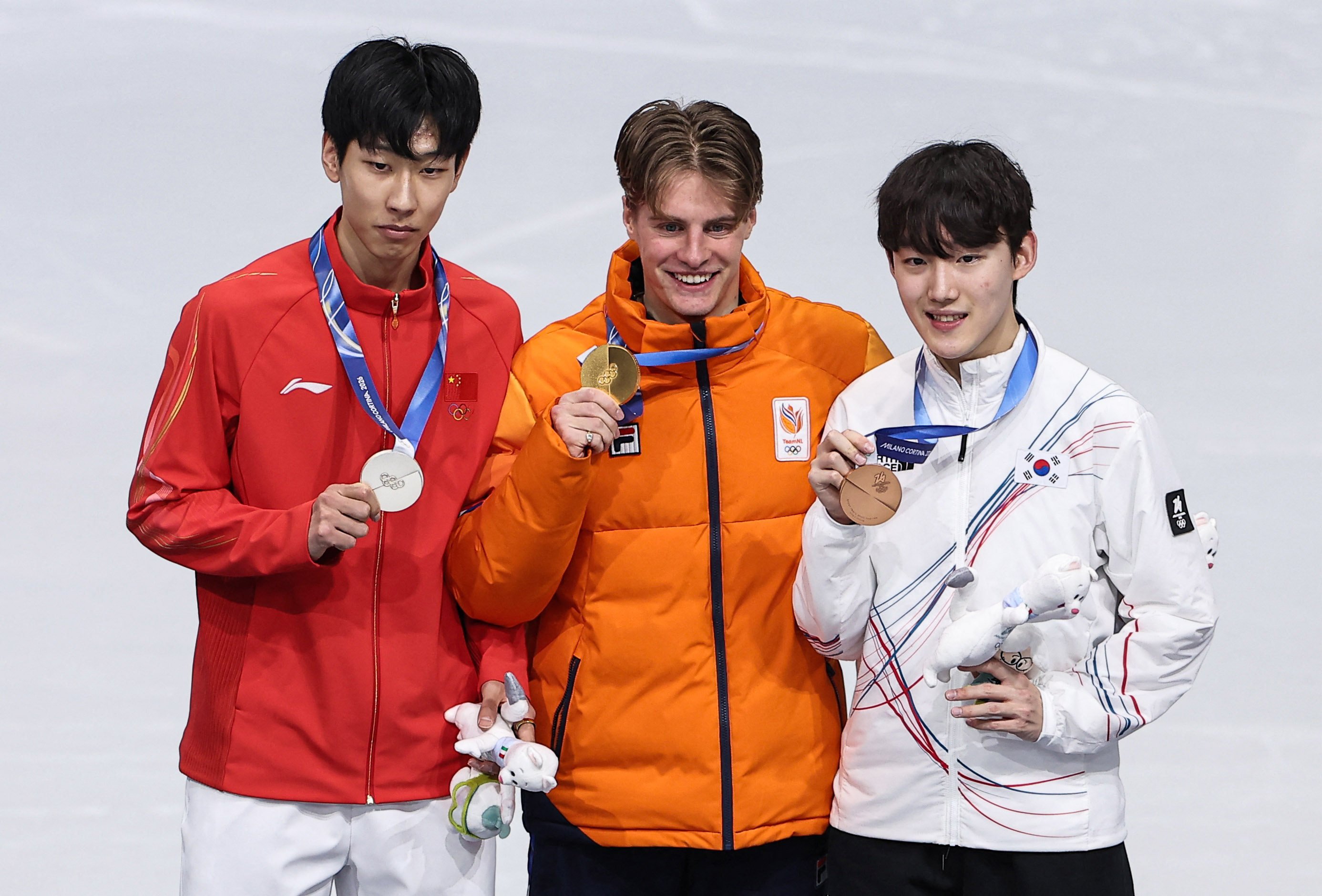 China’s Sun Long (left) holds his silver medal alongside champion Jens Van’t Wout and bronze medallist Rim Jong-un. Photo: Reuters