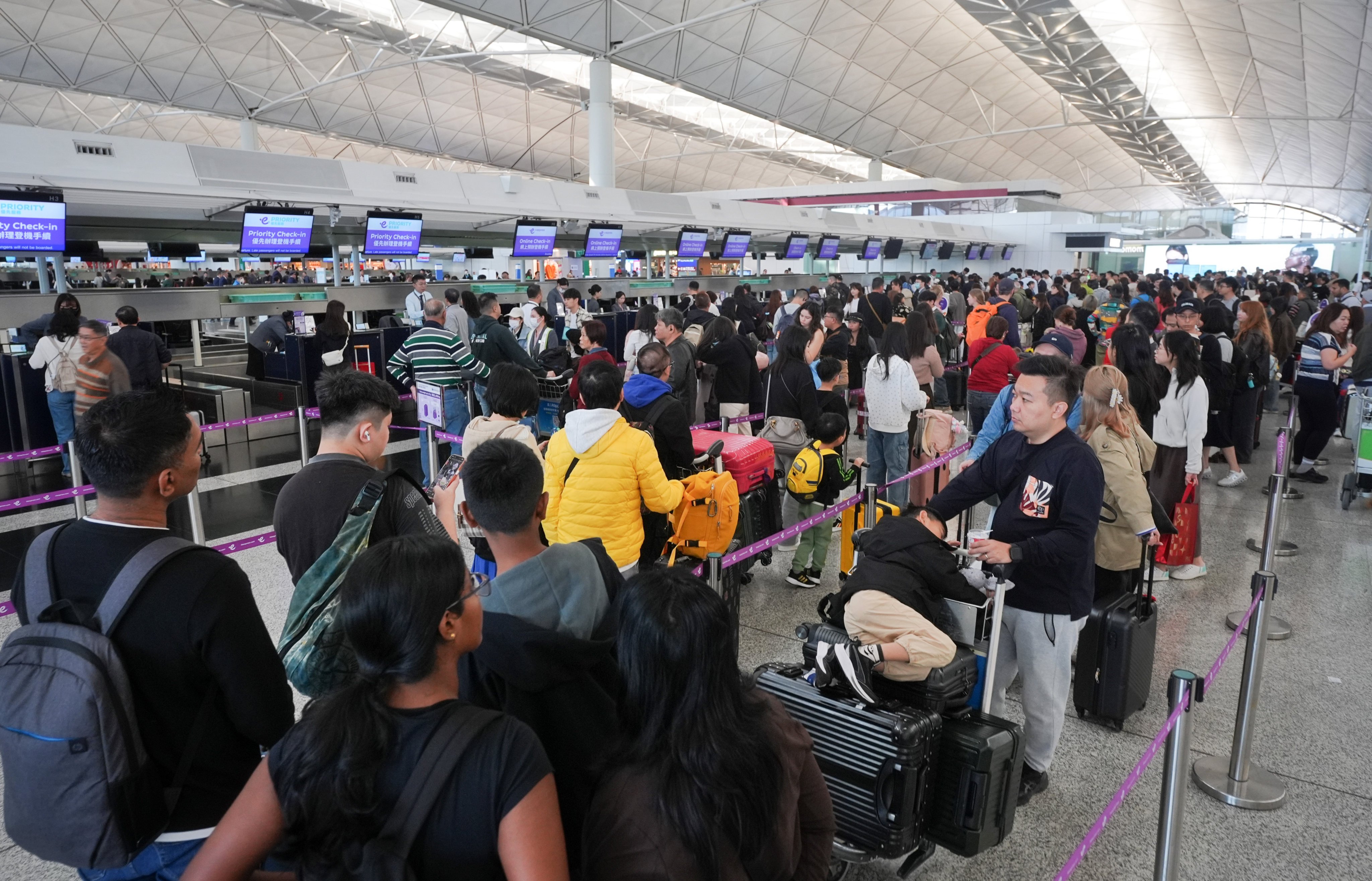 Travellers wait in long queues to check in at Hong Kong International Airport. Photo: Elson Li