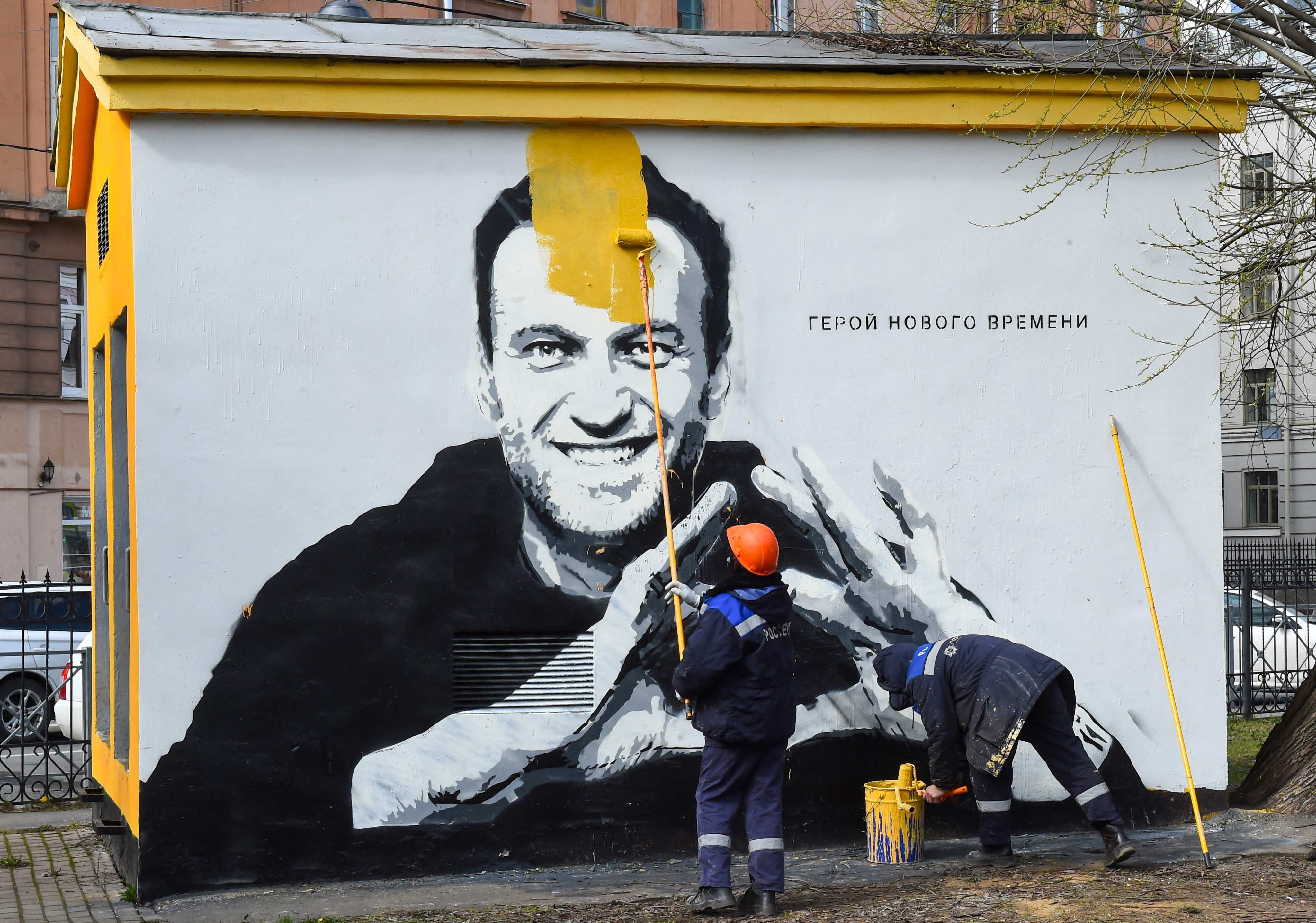 A worker paints over graffiti of jailed Kremlin critic Alexei Navalny in St Petersburg in April 2021. The inscription reads: “The hero of the new times.” Photo: AFP