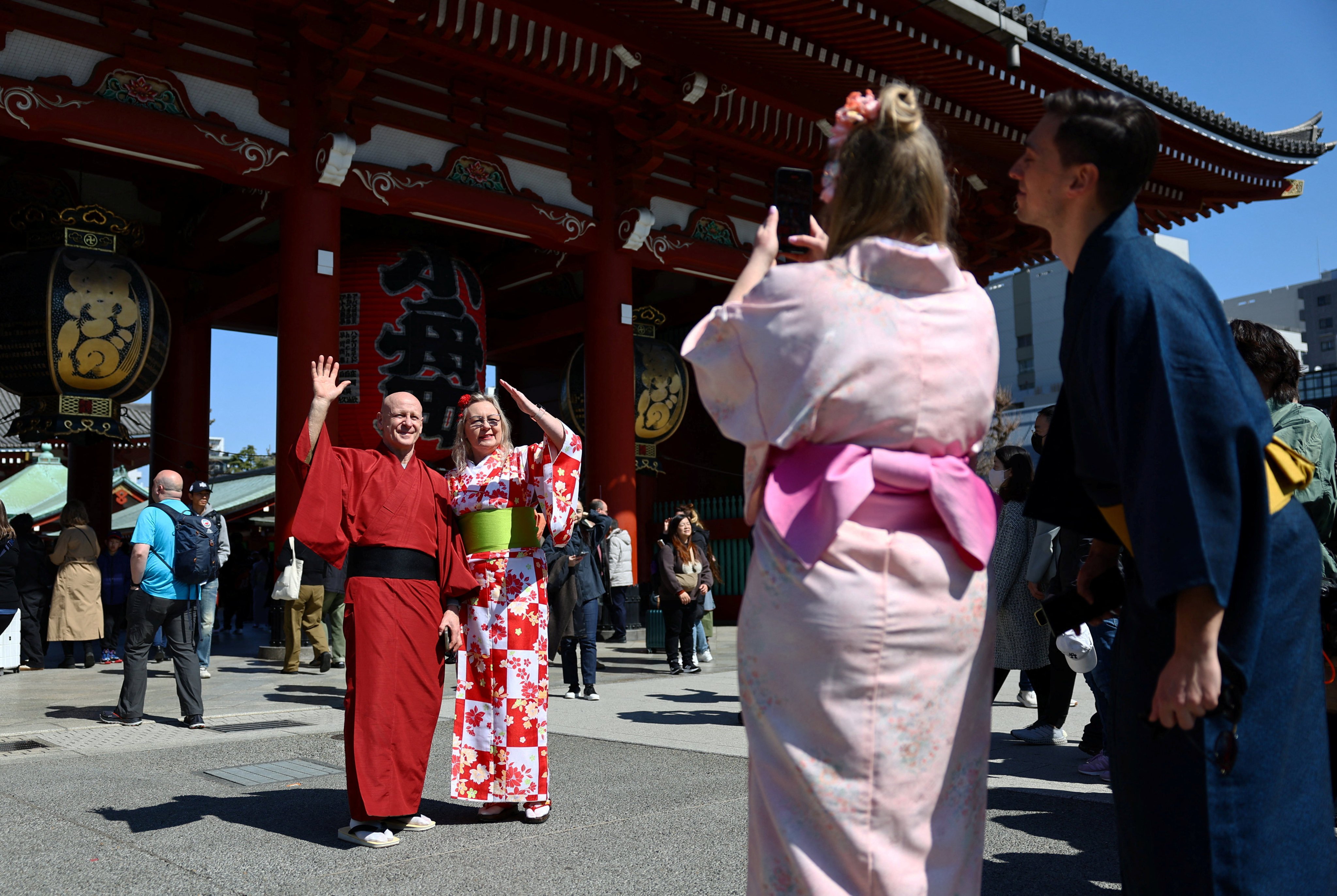 Foreign tourists wearing Japanese traditional kimono clothes pose for a photograph near Sensoji temple at Asakusa district, a popular sightseeing spot in Tokyo. Photo: Reuters