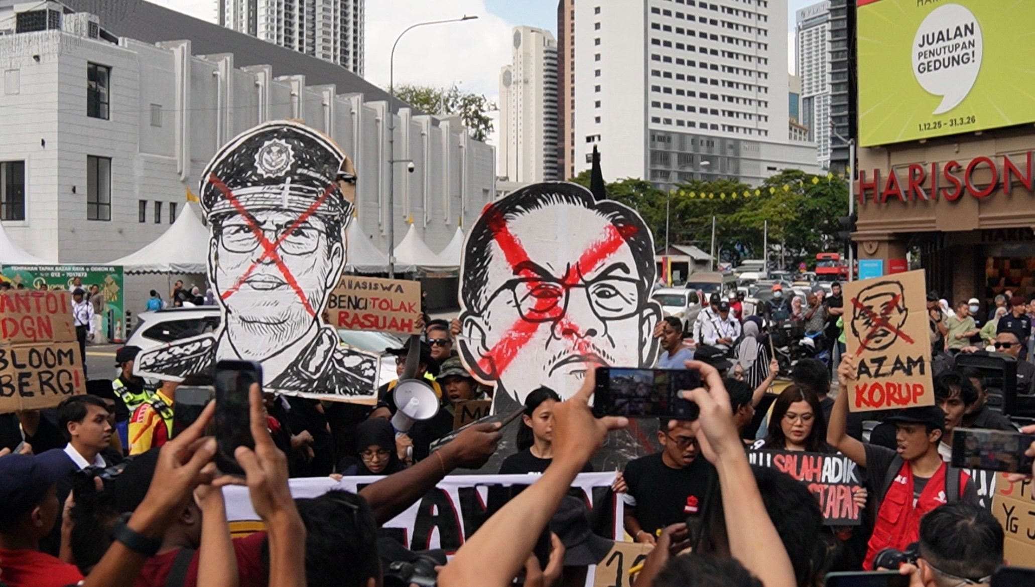Malaysian protestors carry placards with the faces of MACC head Azam Baki (left) and Prime Minister Anwar Ibrahim on Sunday. Photo: X/Rafizi Ramli