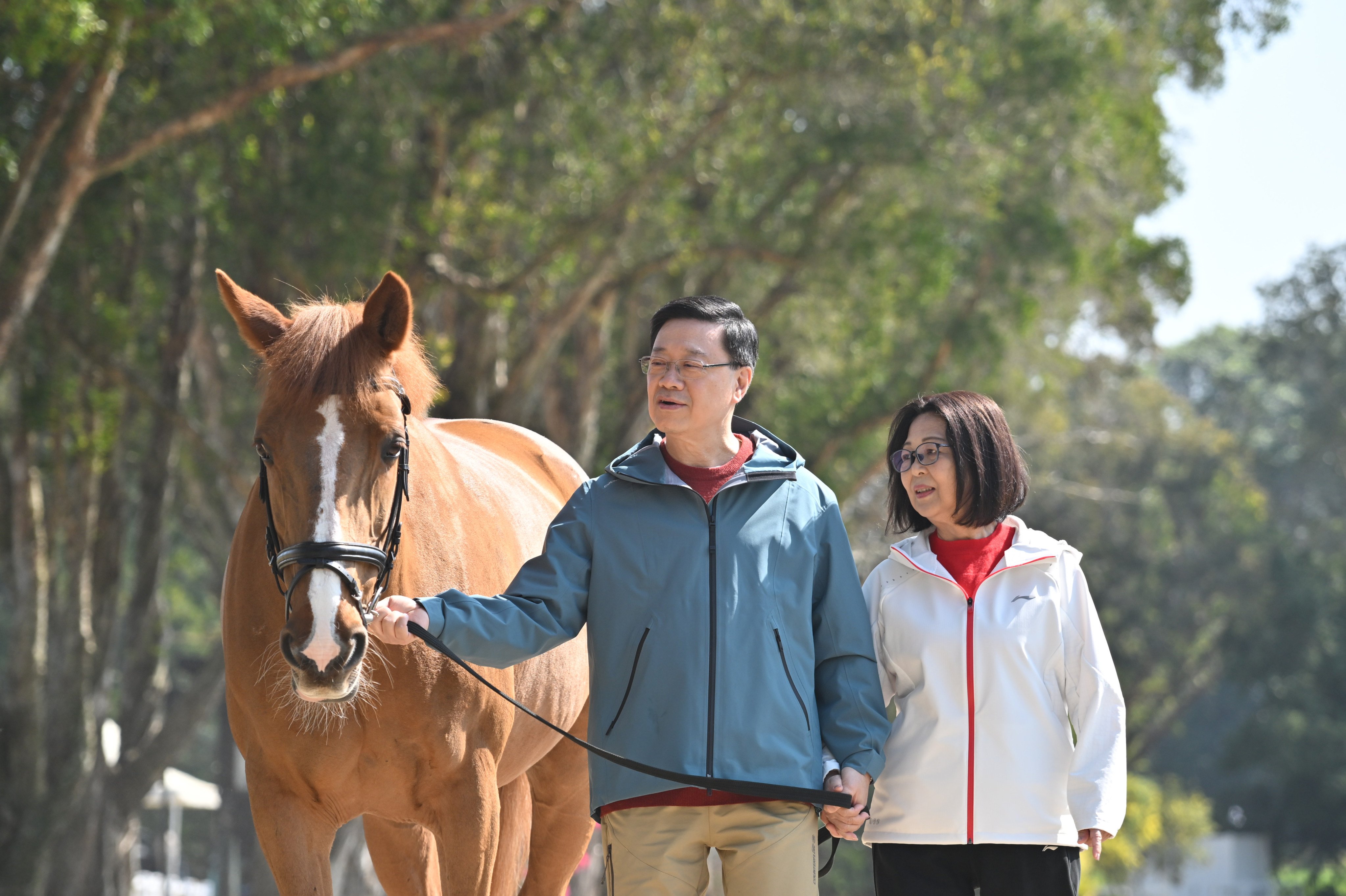 City leader John Lee and his wife, Janet Lee, lead a horse on a stroll in their Lunar New Year video message. Photo: ISD