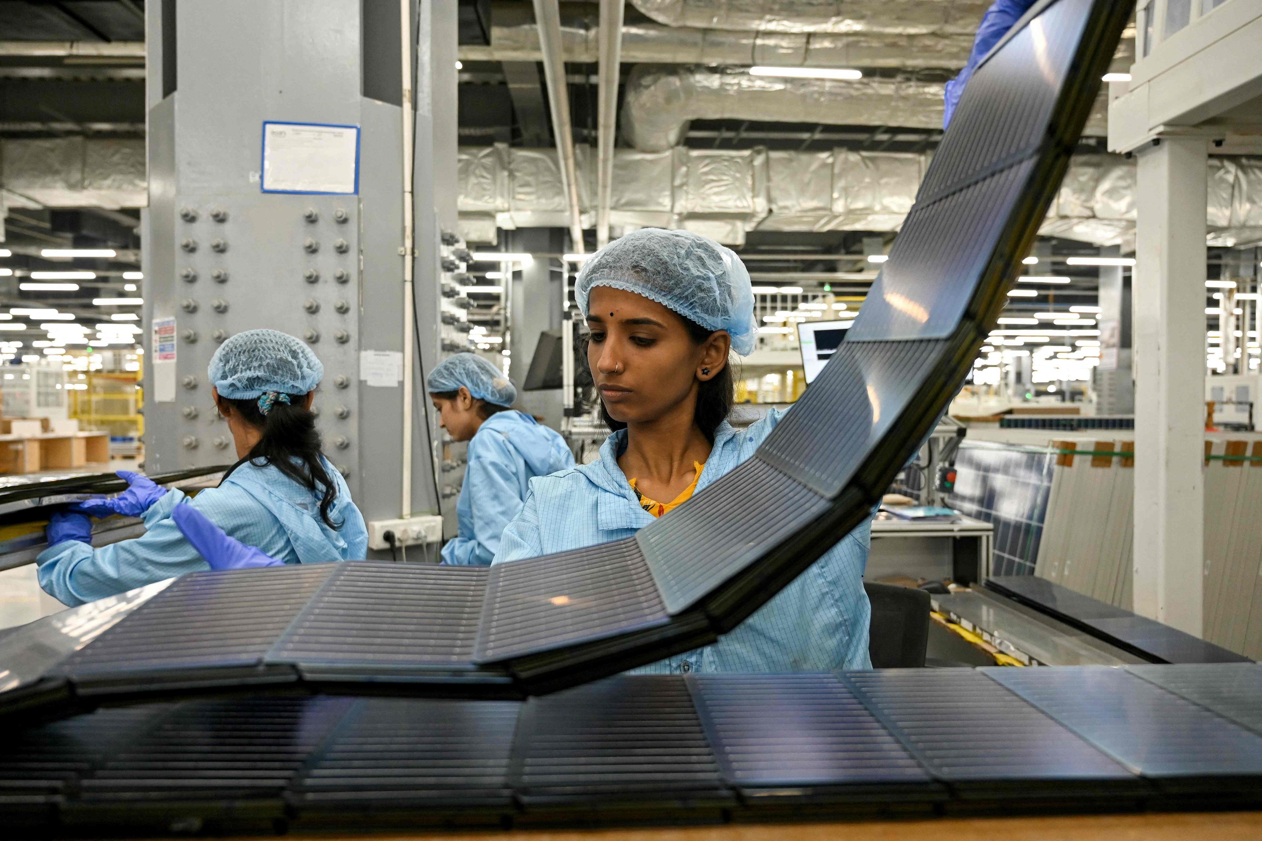 Employees inspect photovoltaic cells used in solar panels at an Adani Group factory in Mundra, India, on November 5, 2025. Photo: AFP