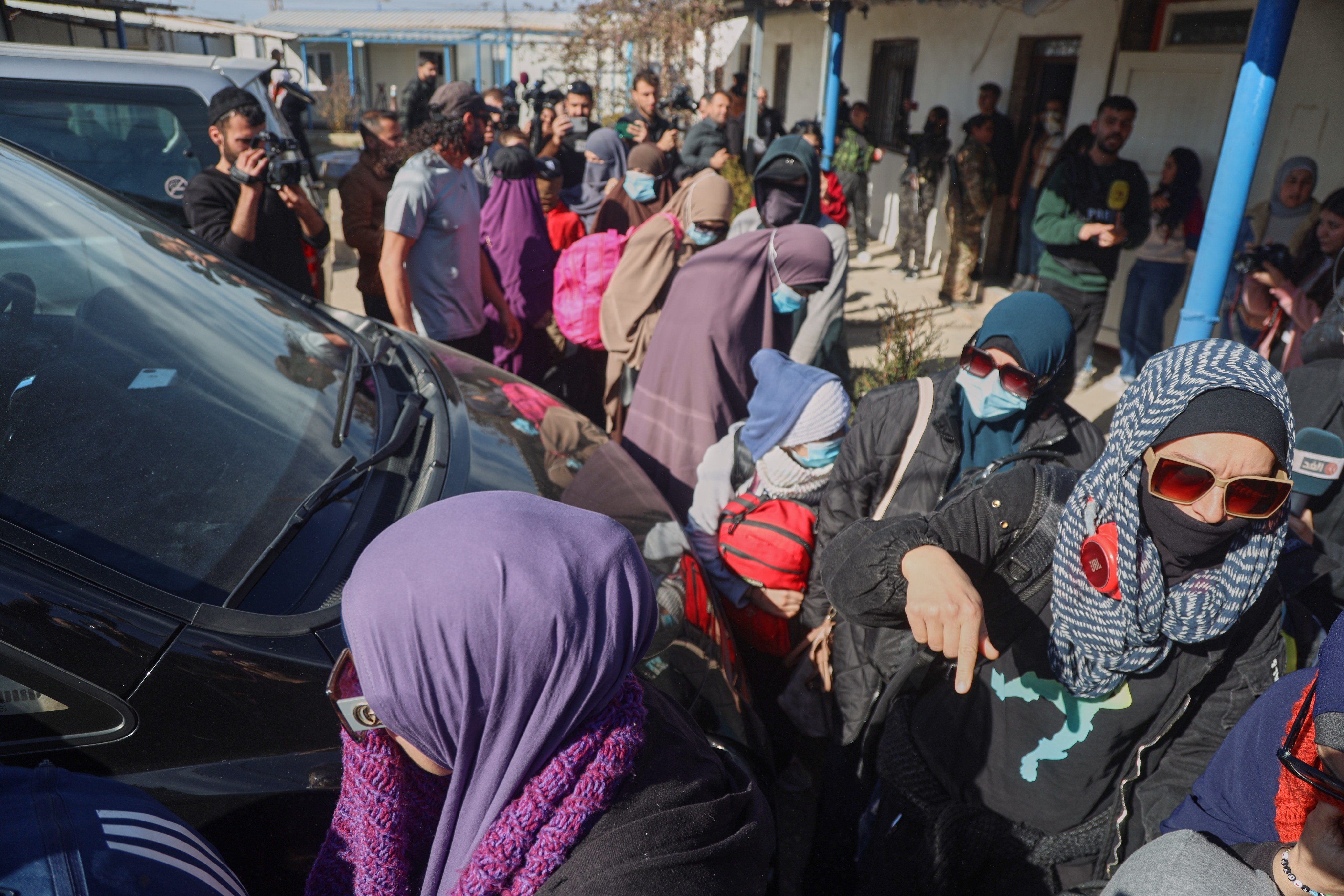 Australian family members of suspected Isis militants walk toward a van bound for the airport during the first repatriation operation of the year at Roj Camp in eastern Syria on Monday. Photo: AP
