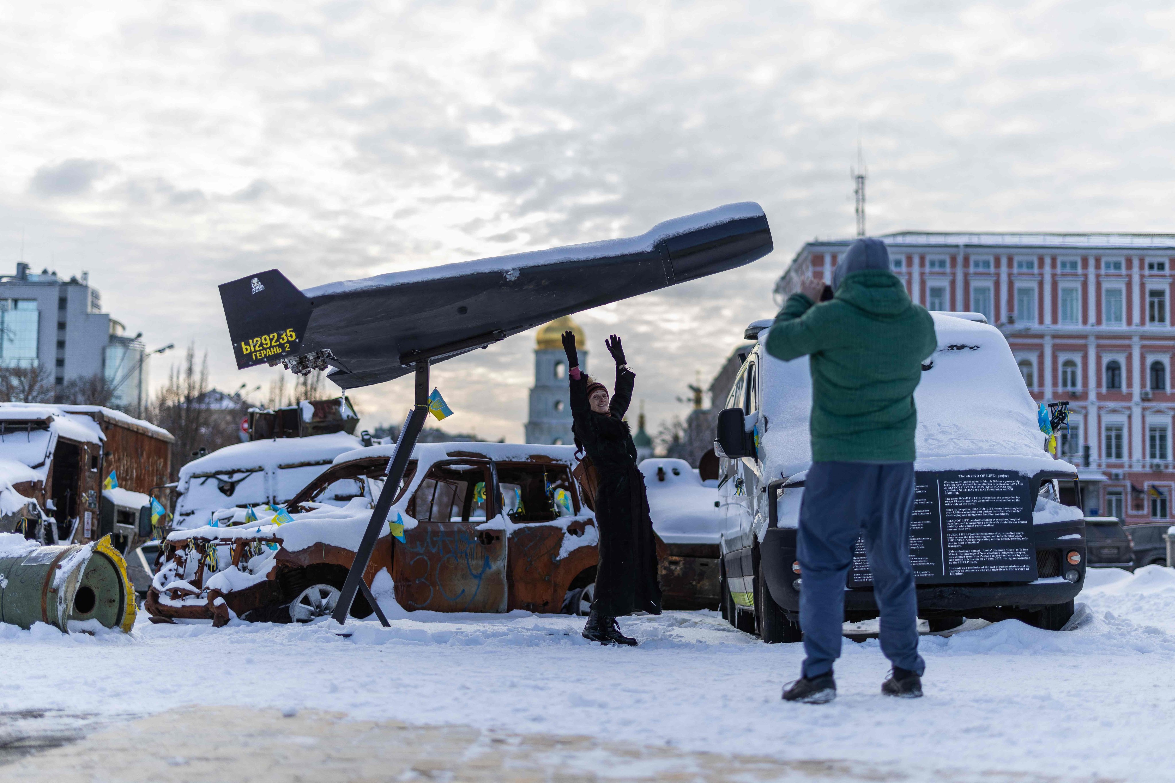 A woman poses underneath a downed Shaded drone at an exhibition of Russian military equipment in Kyiv, Ukraine, on Tuesday. Photo: AFP