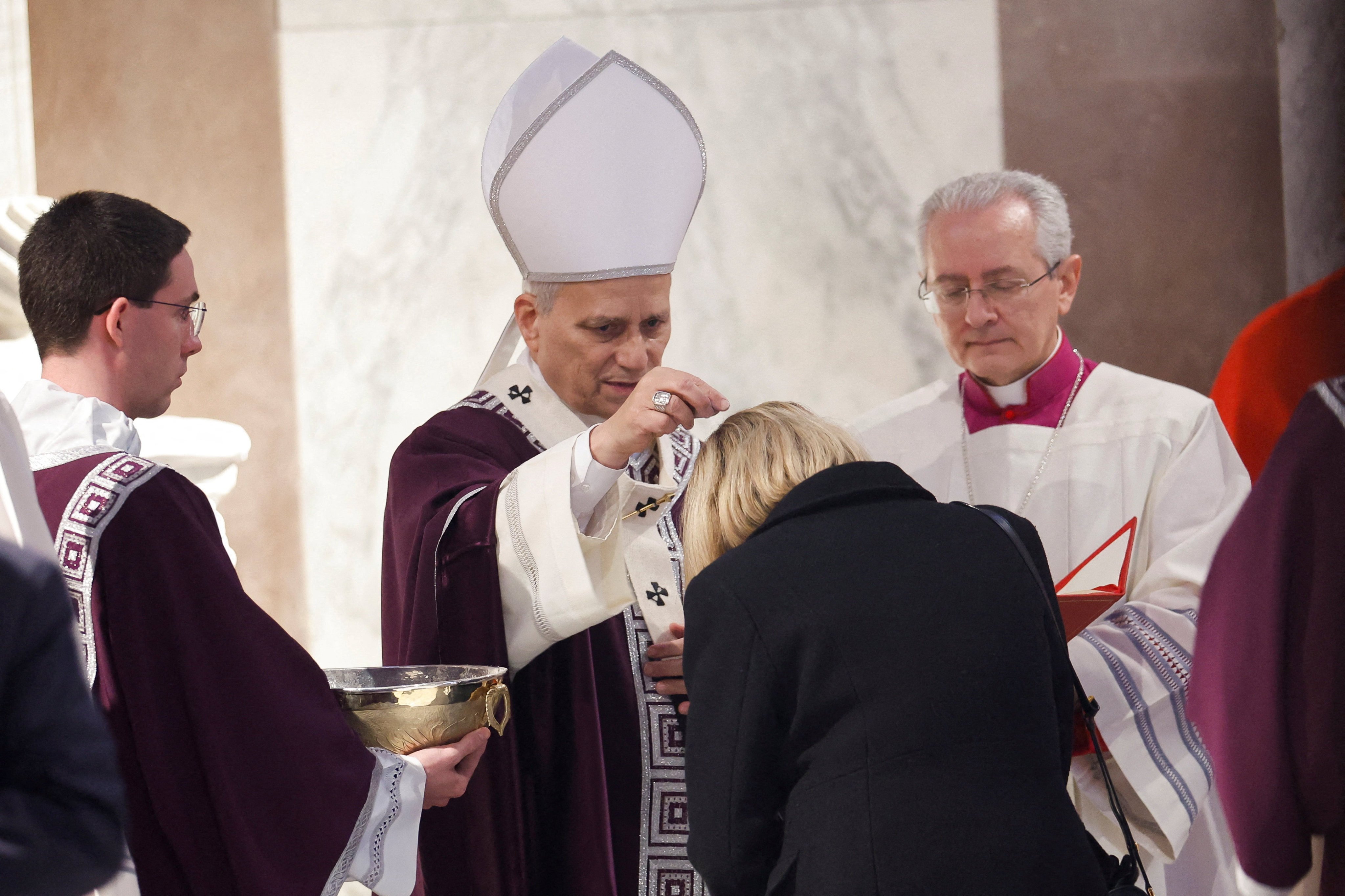 Pope Leo XIV puts ash on the head of one of the faithful during the Ash Wednesday Mass at the Santa Sabina Basilica in Rome. Photo: Reuters