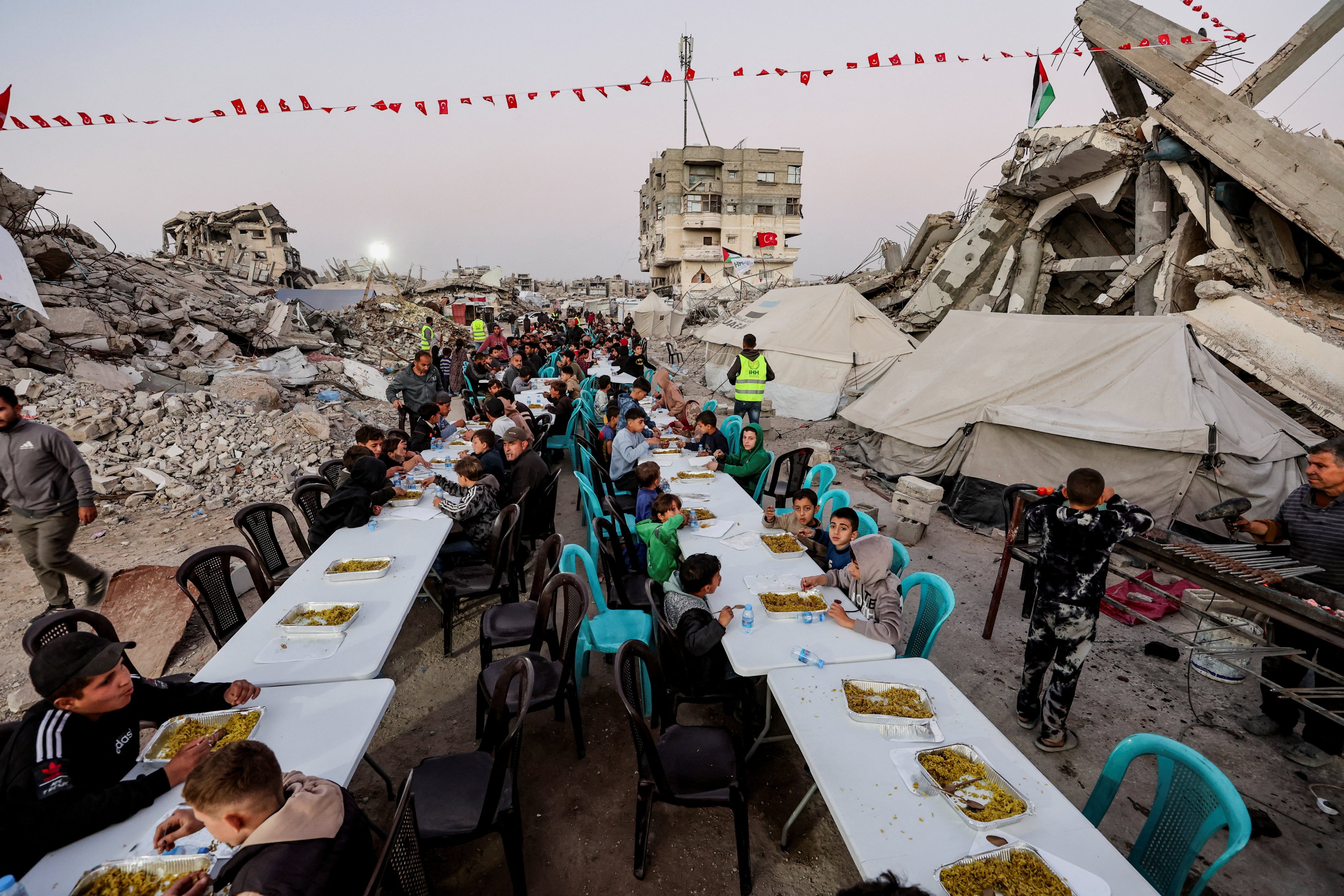 Palestinians gather to break their fast on the first day of the holy month of Ramadan, near the rubble of residential buildings destroyed during the two-year Israeli offensive, in Gaza City, February 18, 2026. Photo: Reuters