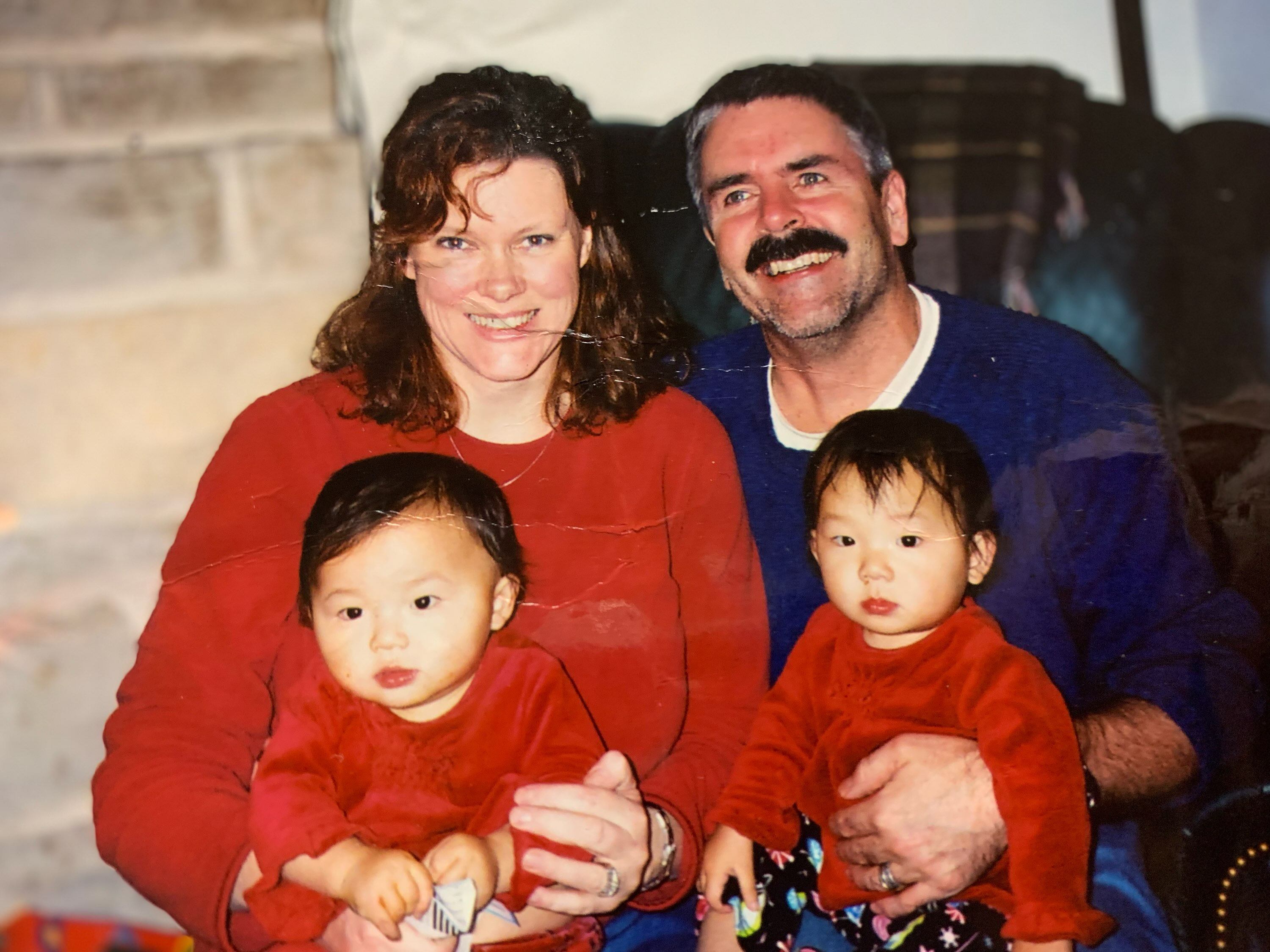 Phoebe McChesney, left, with her twin sister and parents in the US, after their adoption from Hunan, China. Photo: Handout