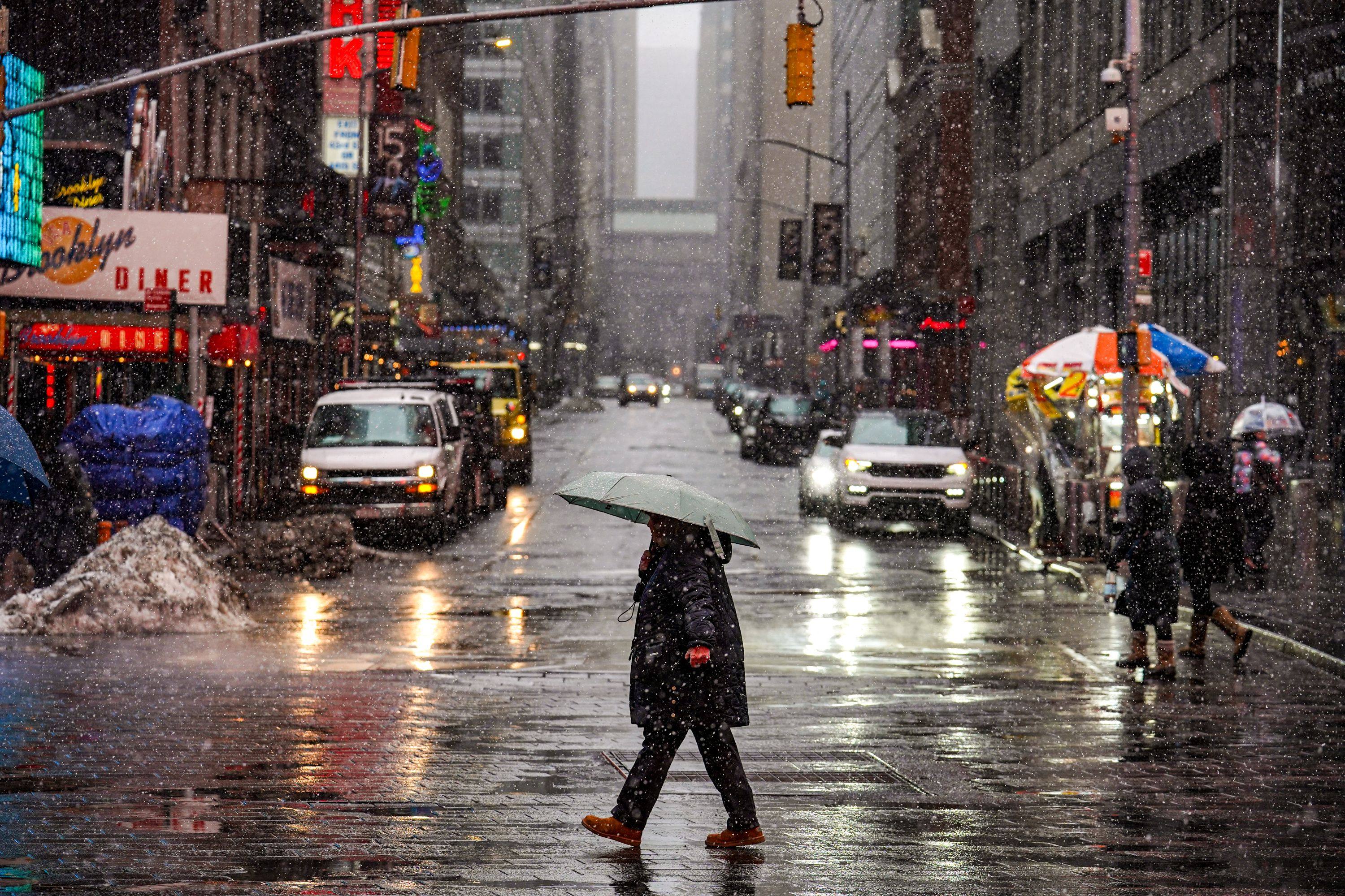 People walk along the street during snowfall on Sunday in New York City ahead of a major winter storm. Photo: Getty Images via AFP
