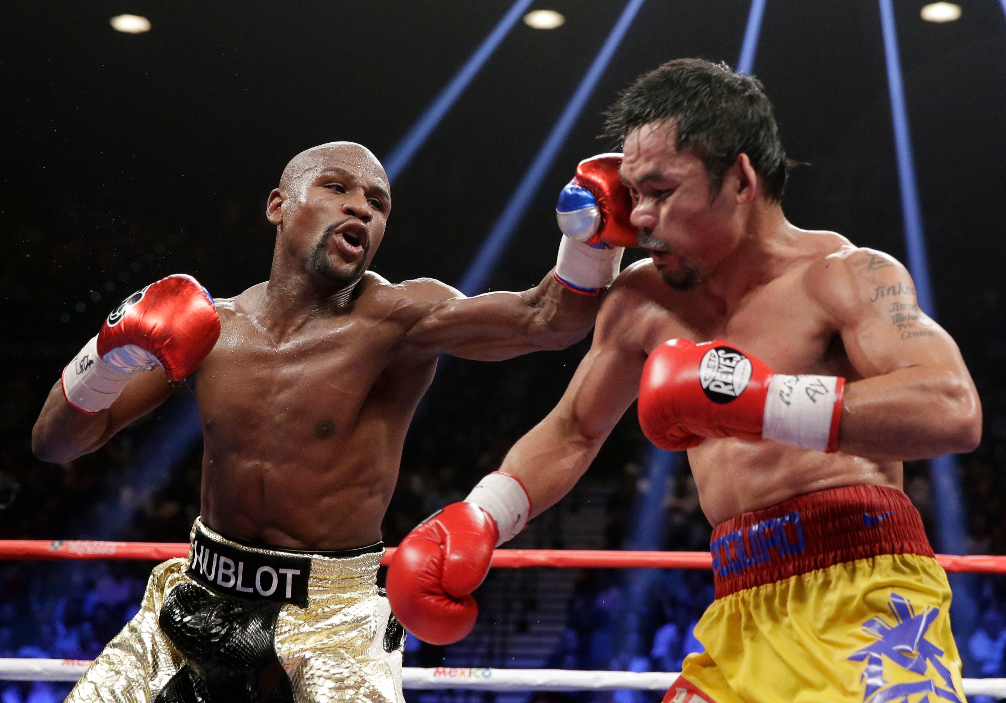 Floyd Mayweather (left) hits Manny Pacquiao during their 2015 welterweight title fight in Las Vegas. Photo: AP